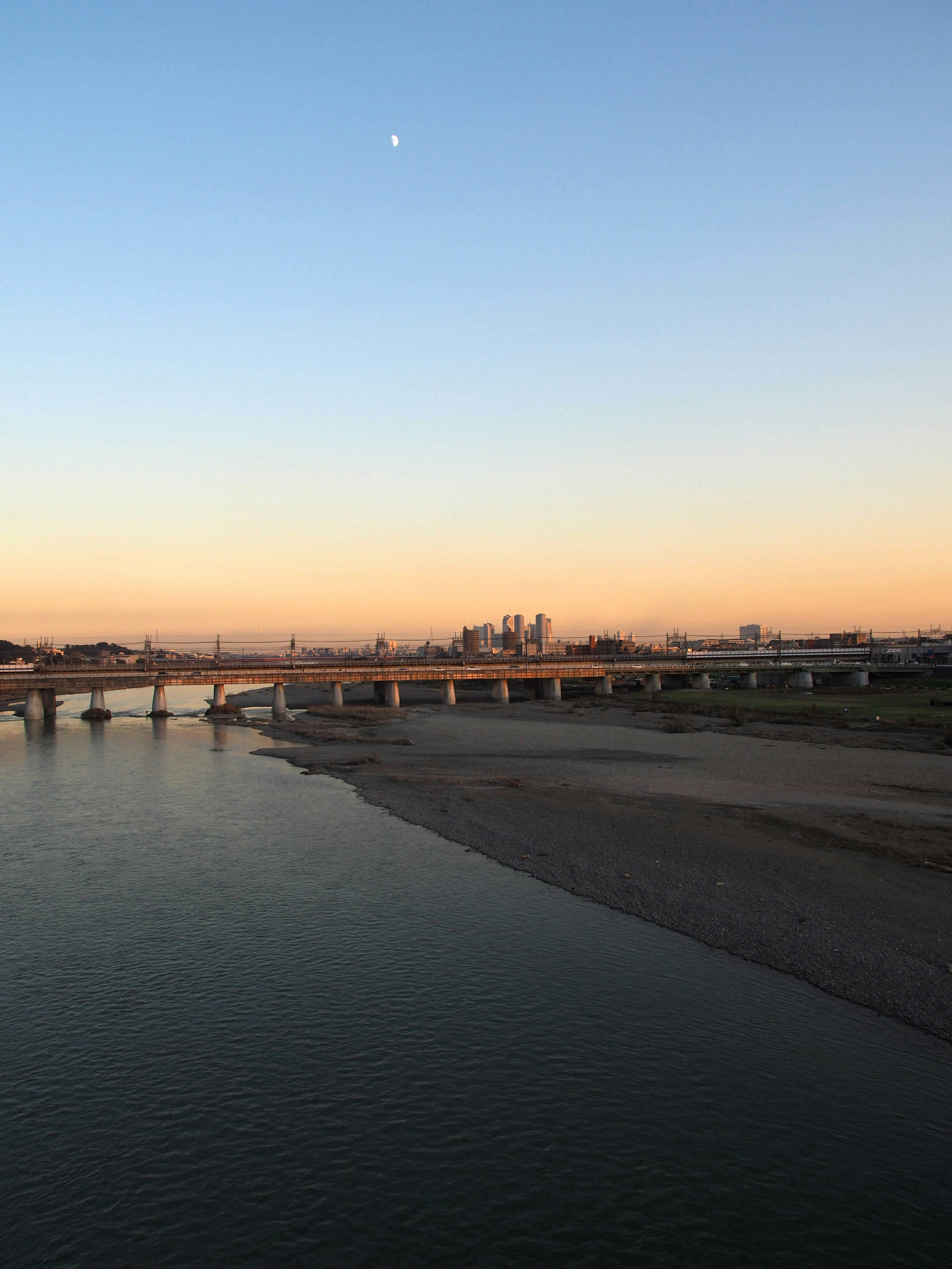 Fluss- und Brückenlandschaft, beleuchtet von Sonnenuntergang