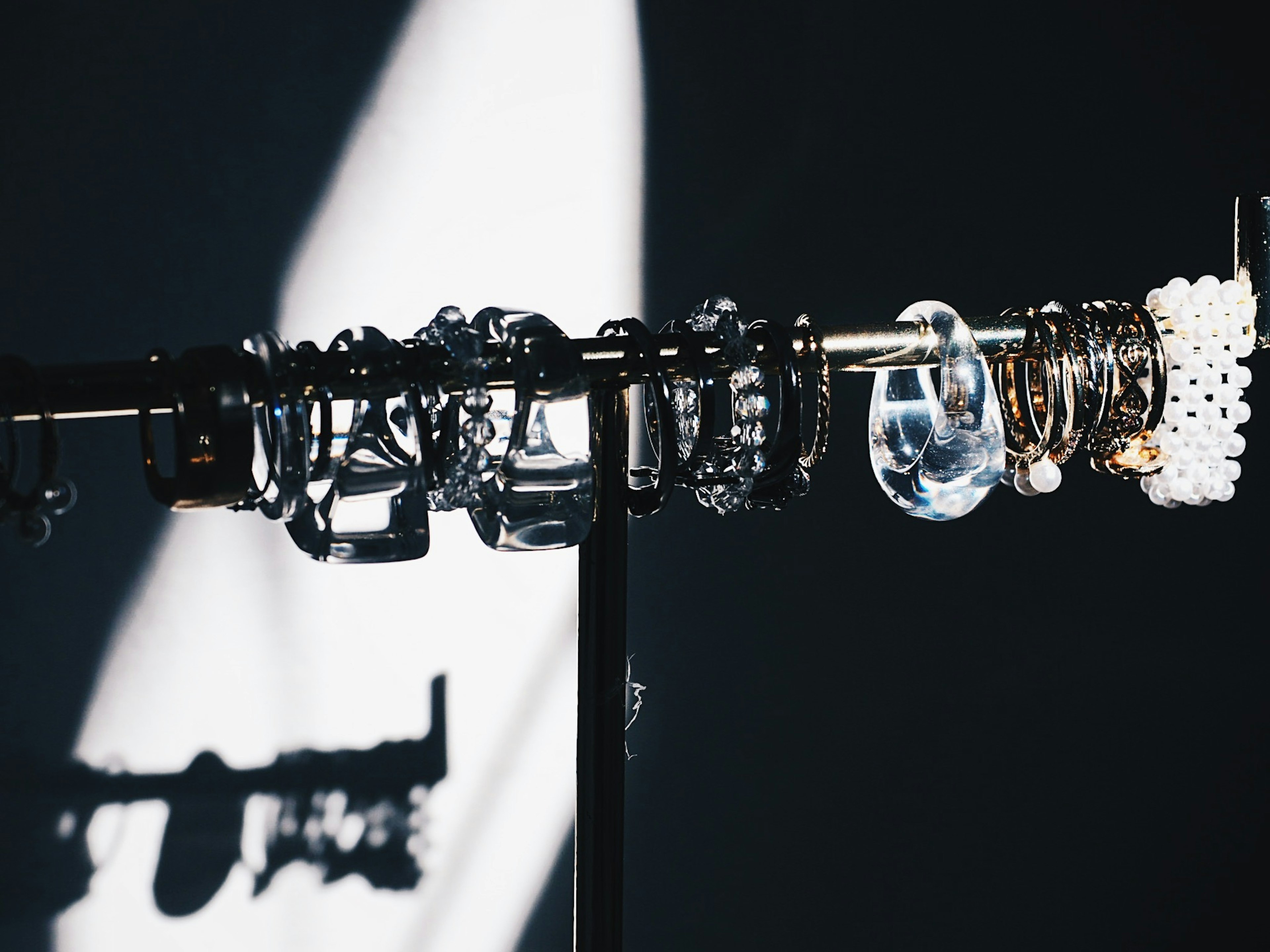 A display of various bracelets on a stand casting a shadow