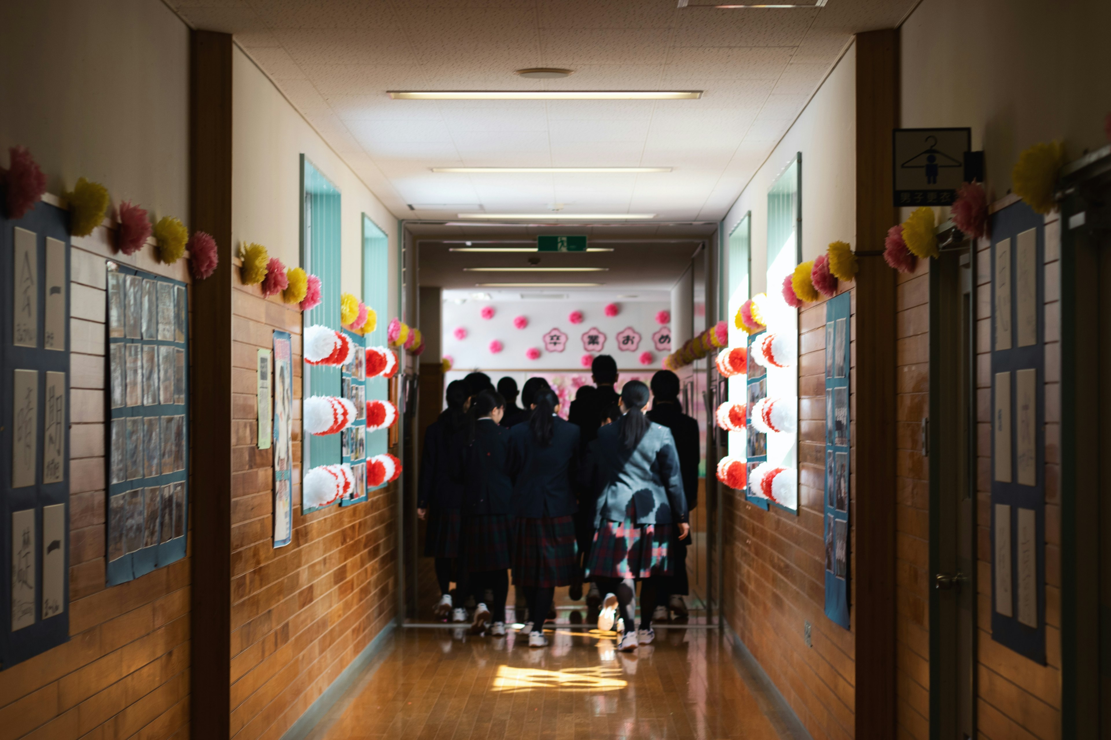 Studenti riuniti in un corridoio scolastico con muri decorati