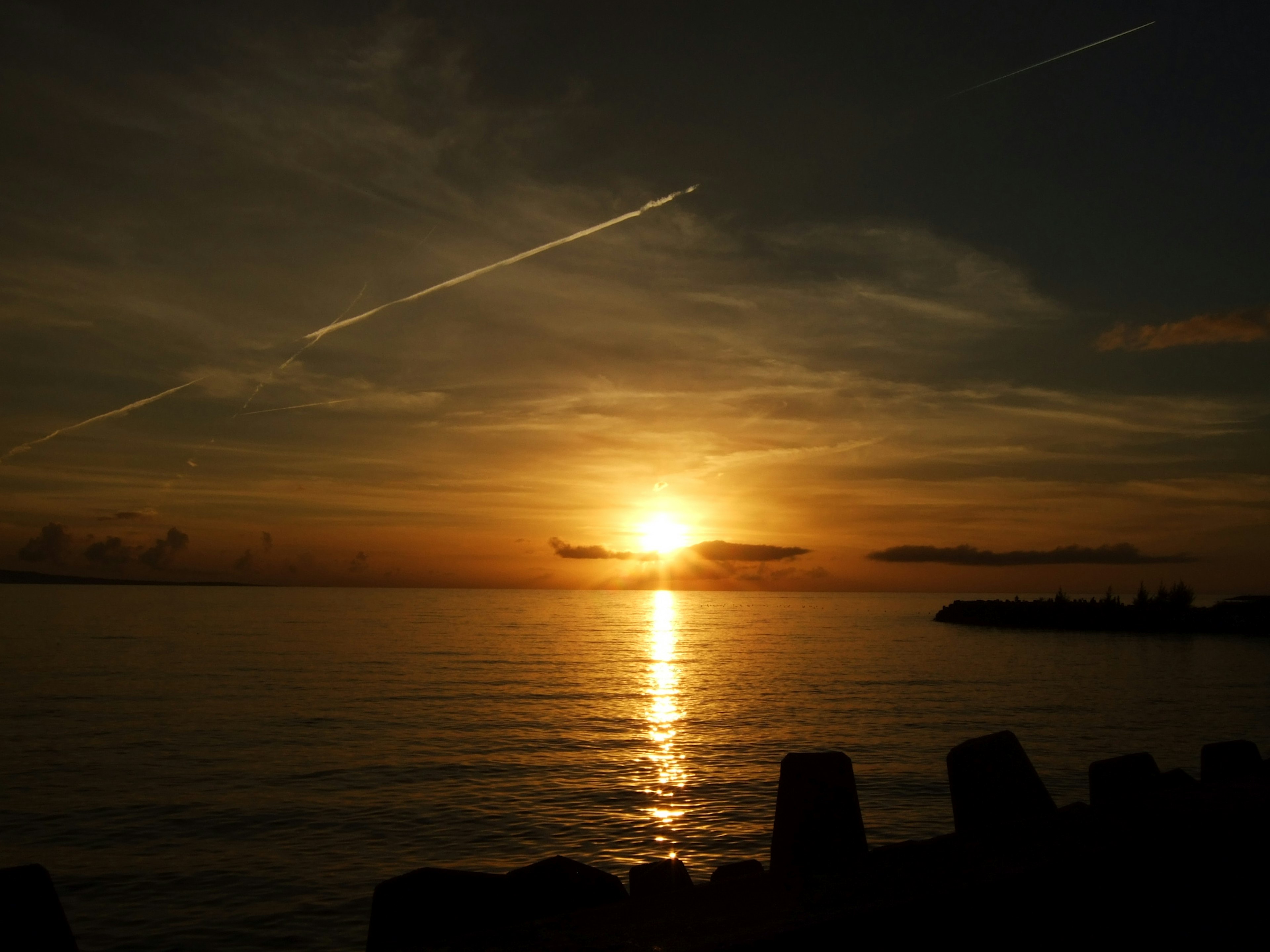 Tramonto che si riflette sull'acqua cielo arancione vibrante e mare calmo