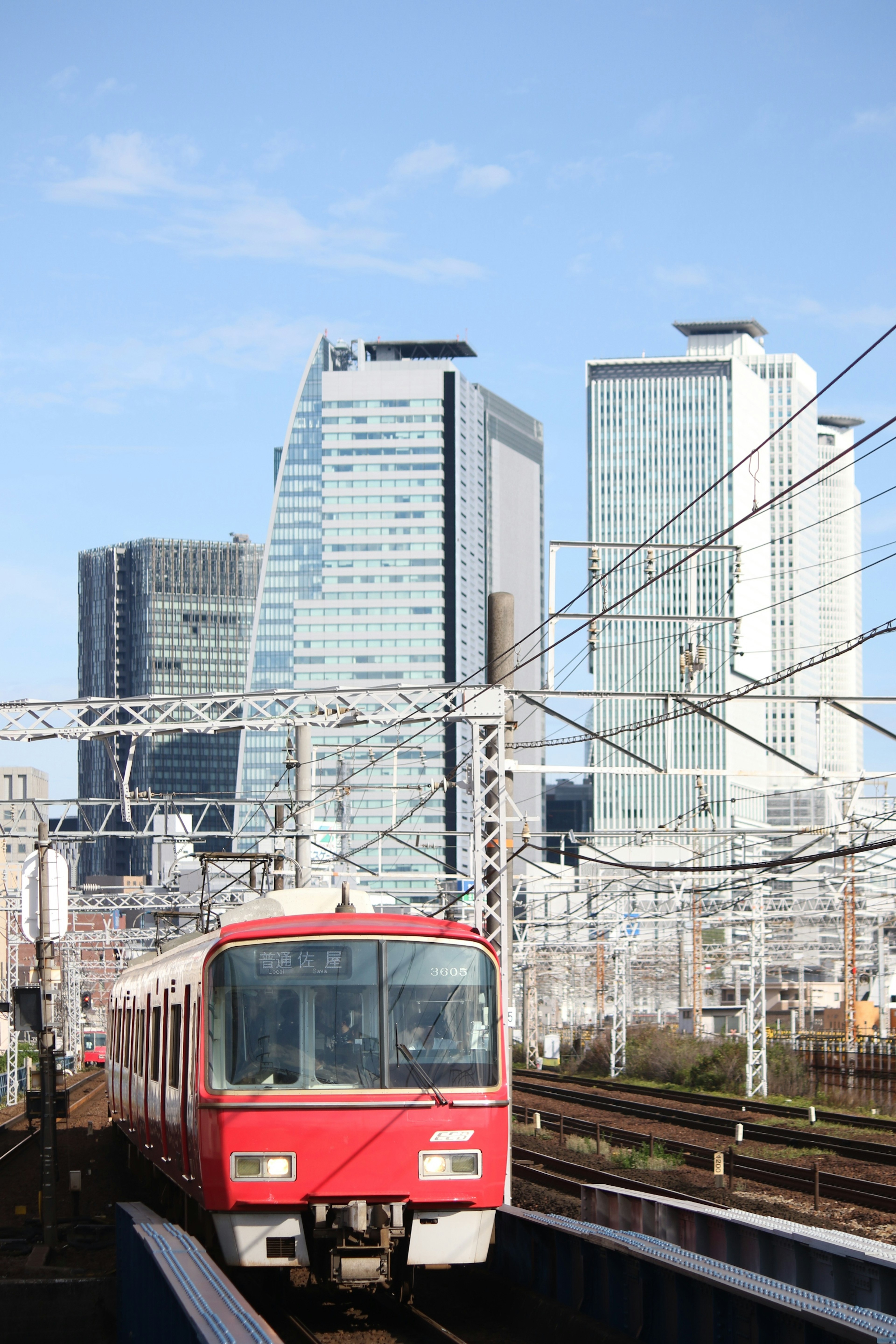 赤い電車が高層ビルの間を走る風景