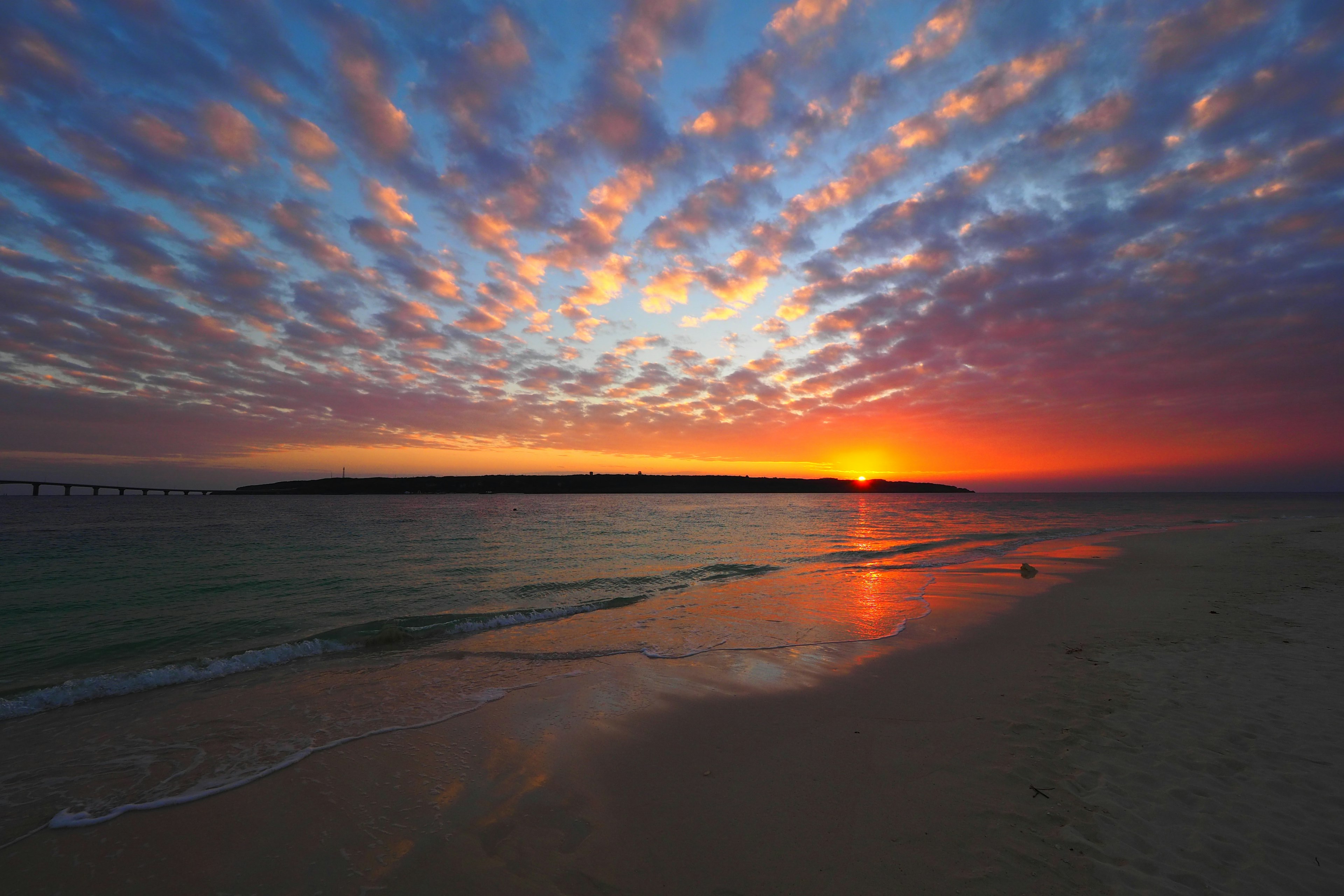 Stunning beach sunset with vibrant orange and blue sky calm waves reflecting light