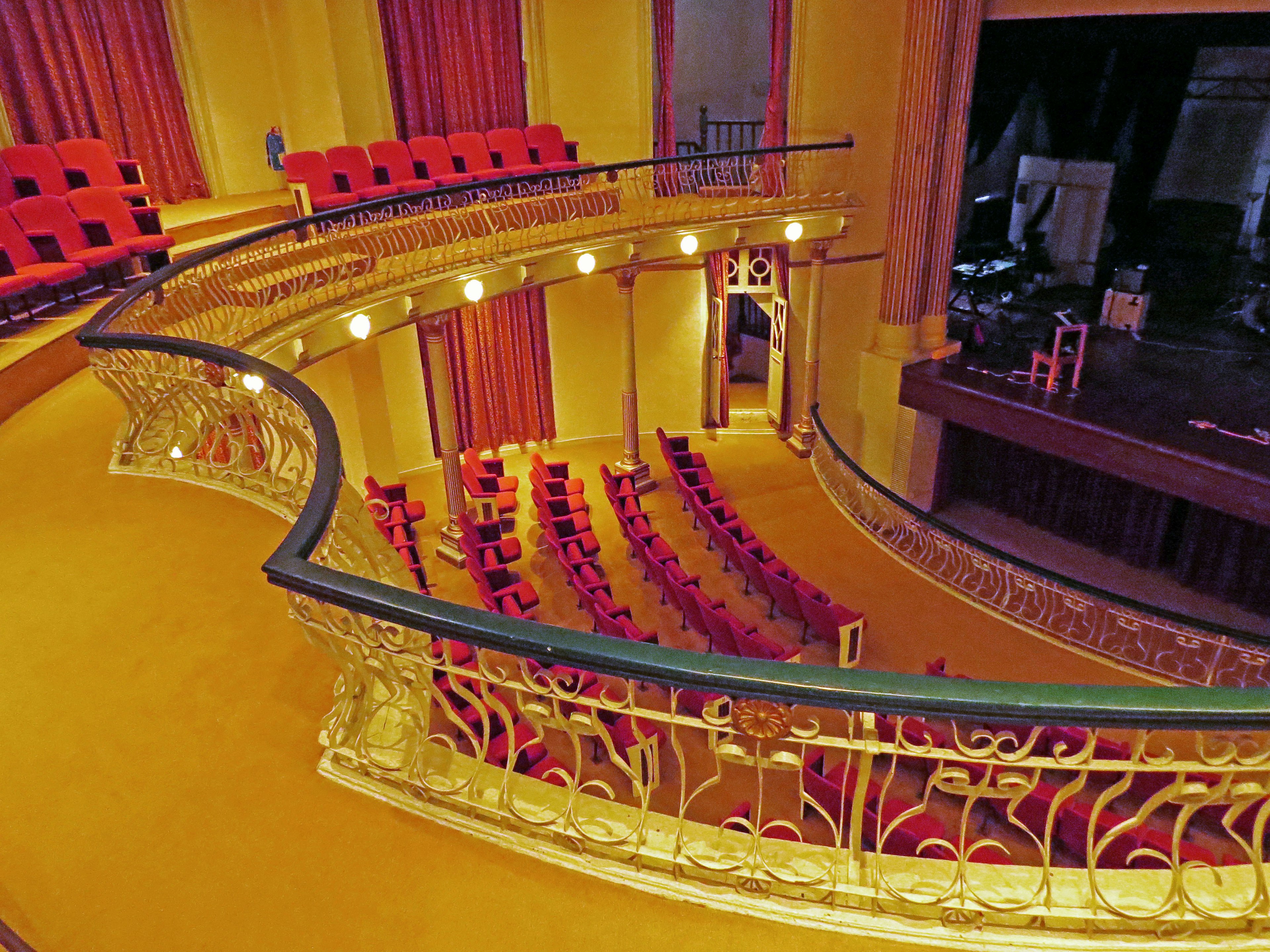 Balcone elegante di un teatro con posti a sedere rossi e ringhiere dorate