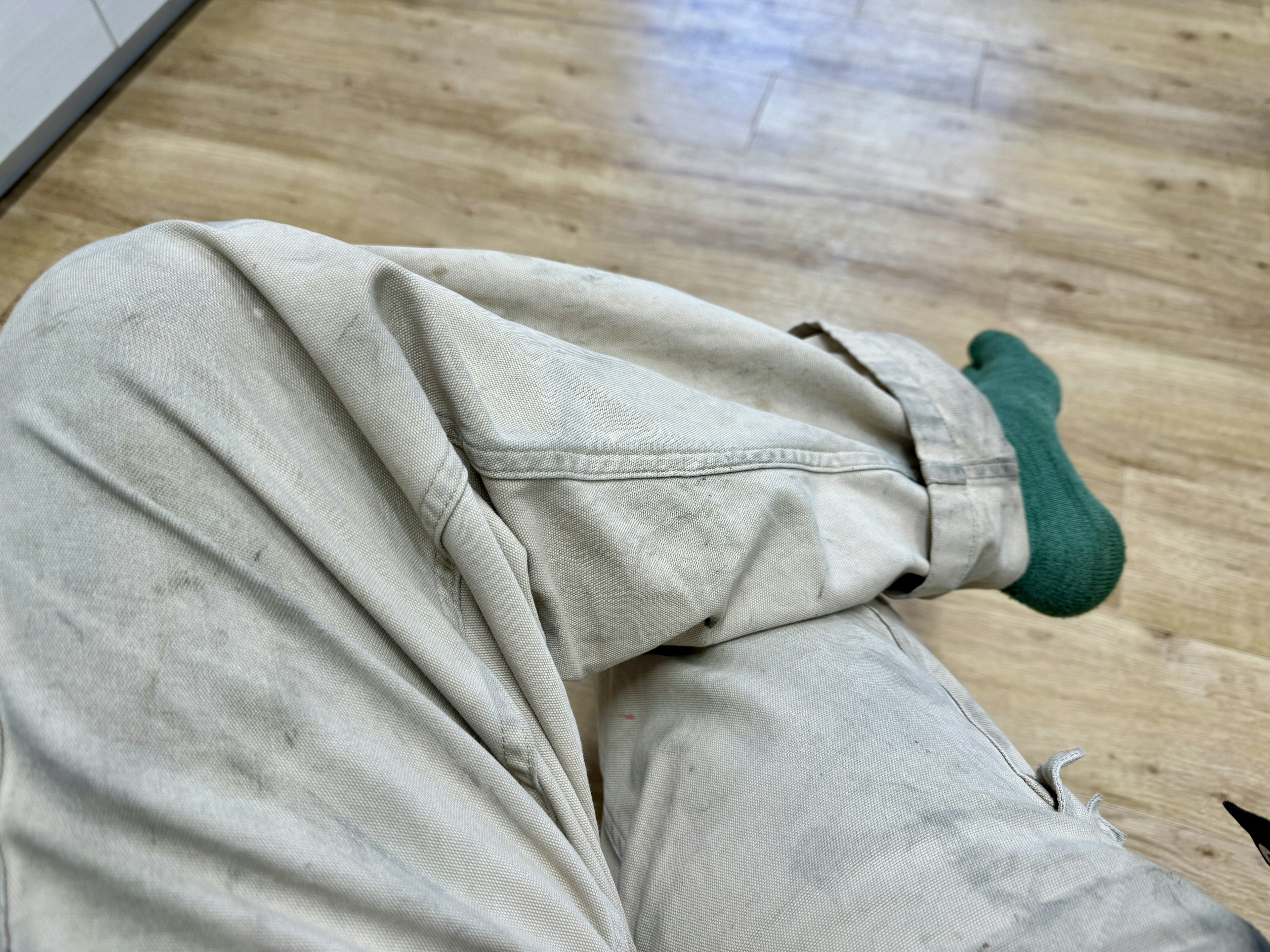 Photo d'une jambe portant un pantalon blanc sale et une chaussette verte