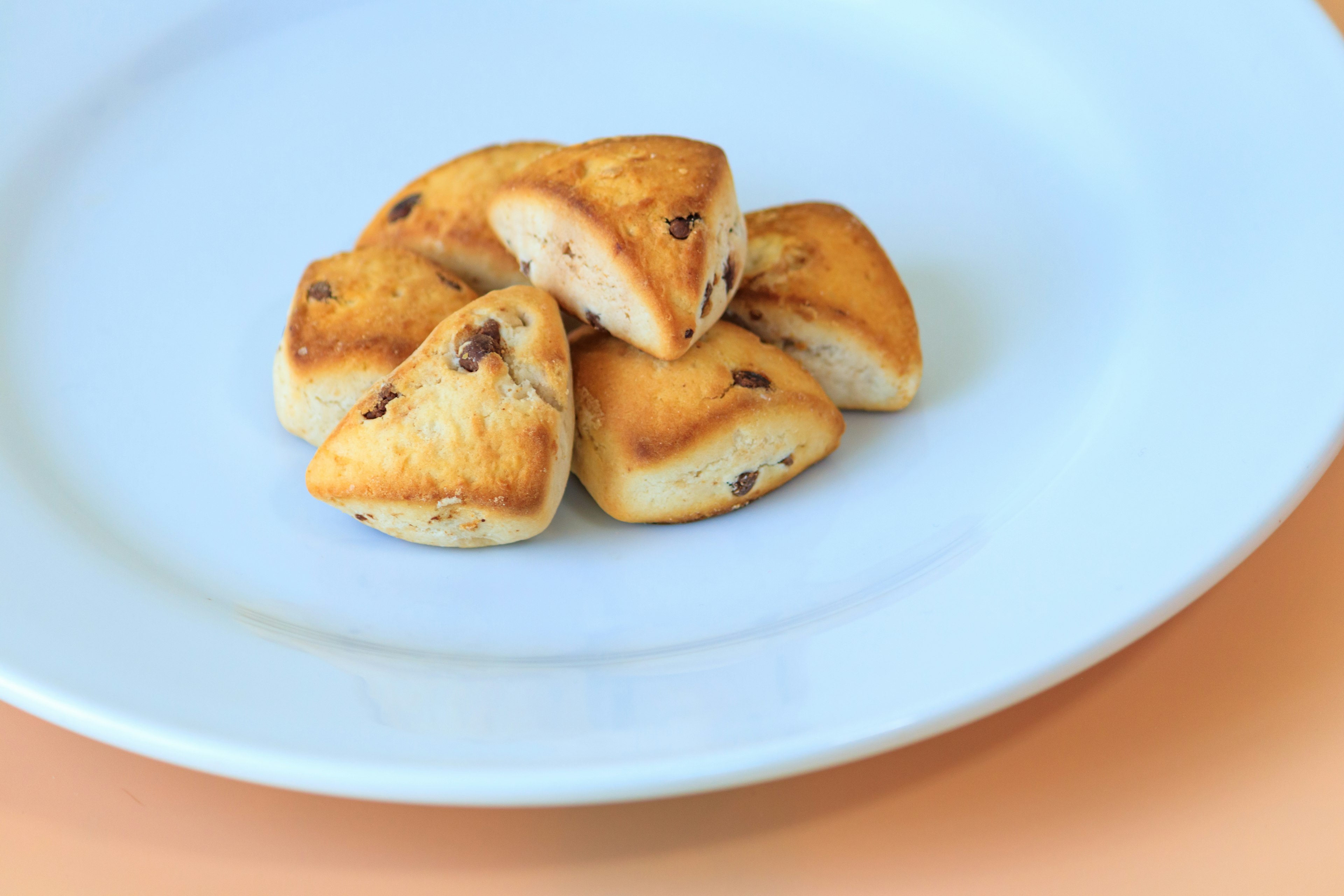 Pequeños pasteles triangulares dorados en un plato blanco