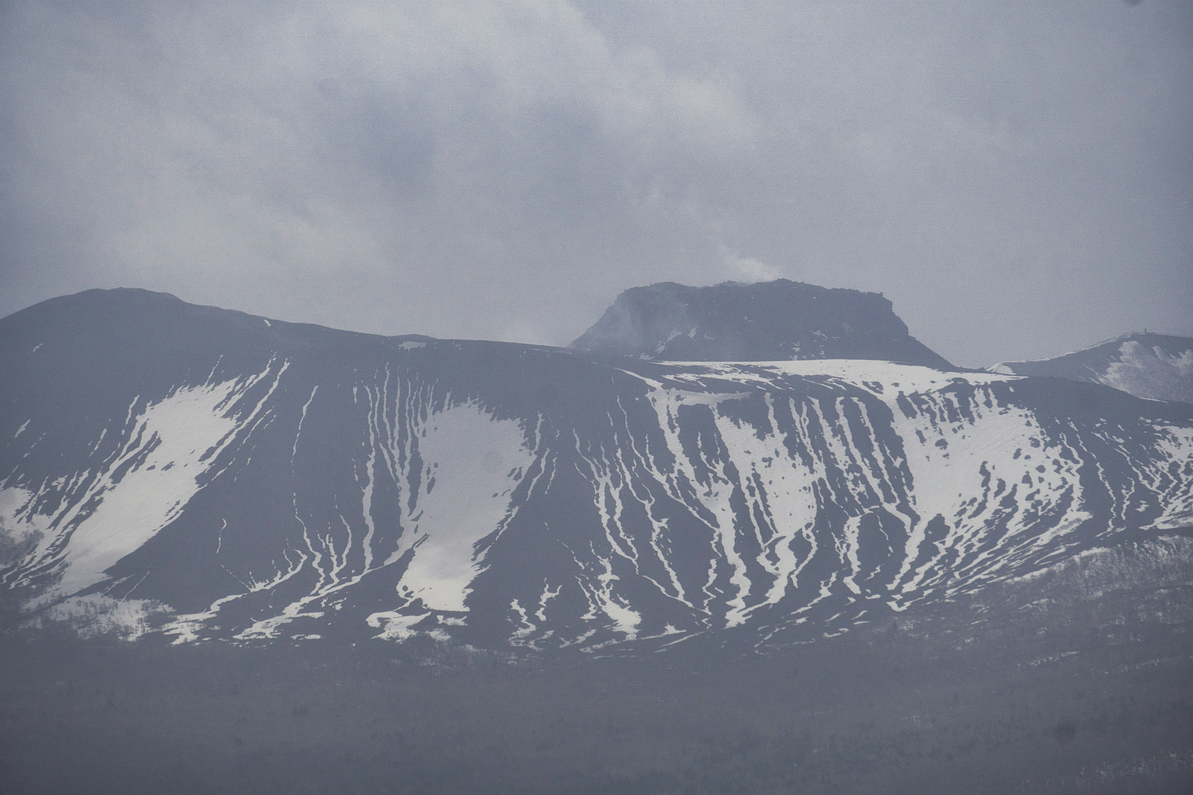 Snow-covered mountain landscape with overcast sky