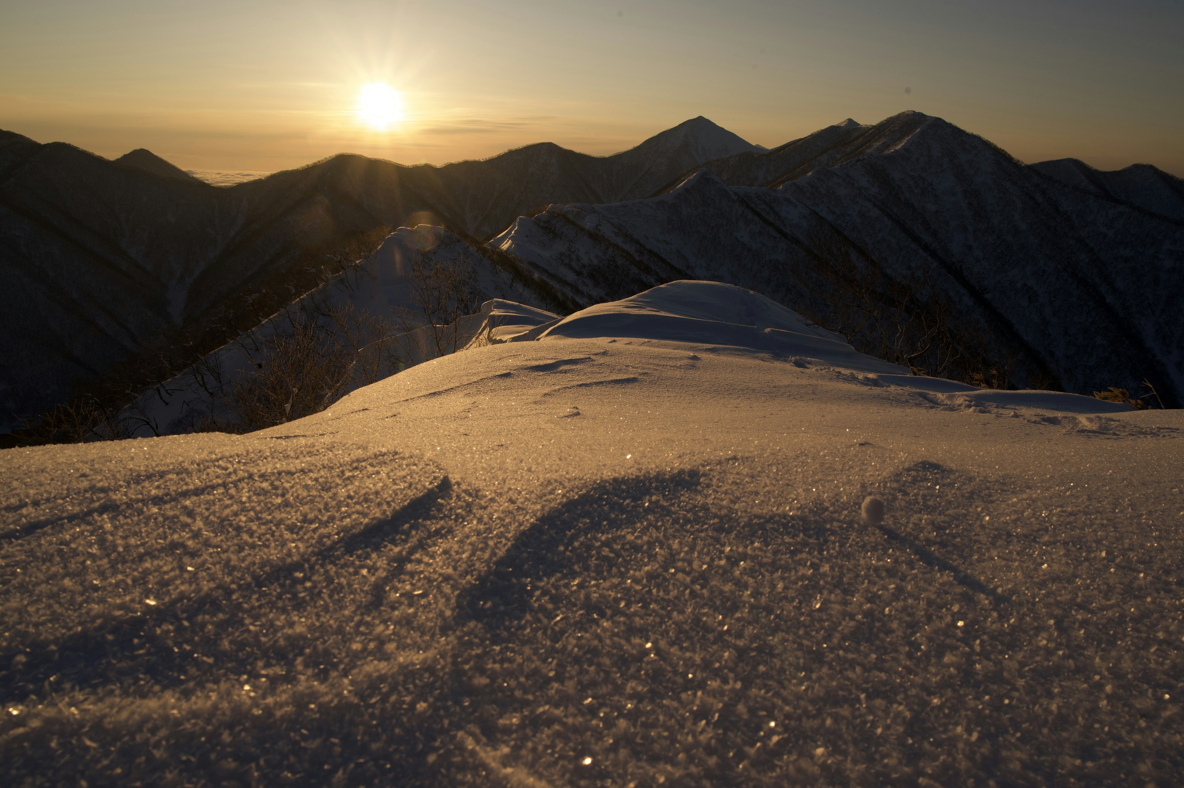 Una vista mozzafiato da una cima innevata con l'alba che illumina il paesaggio