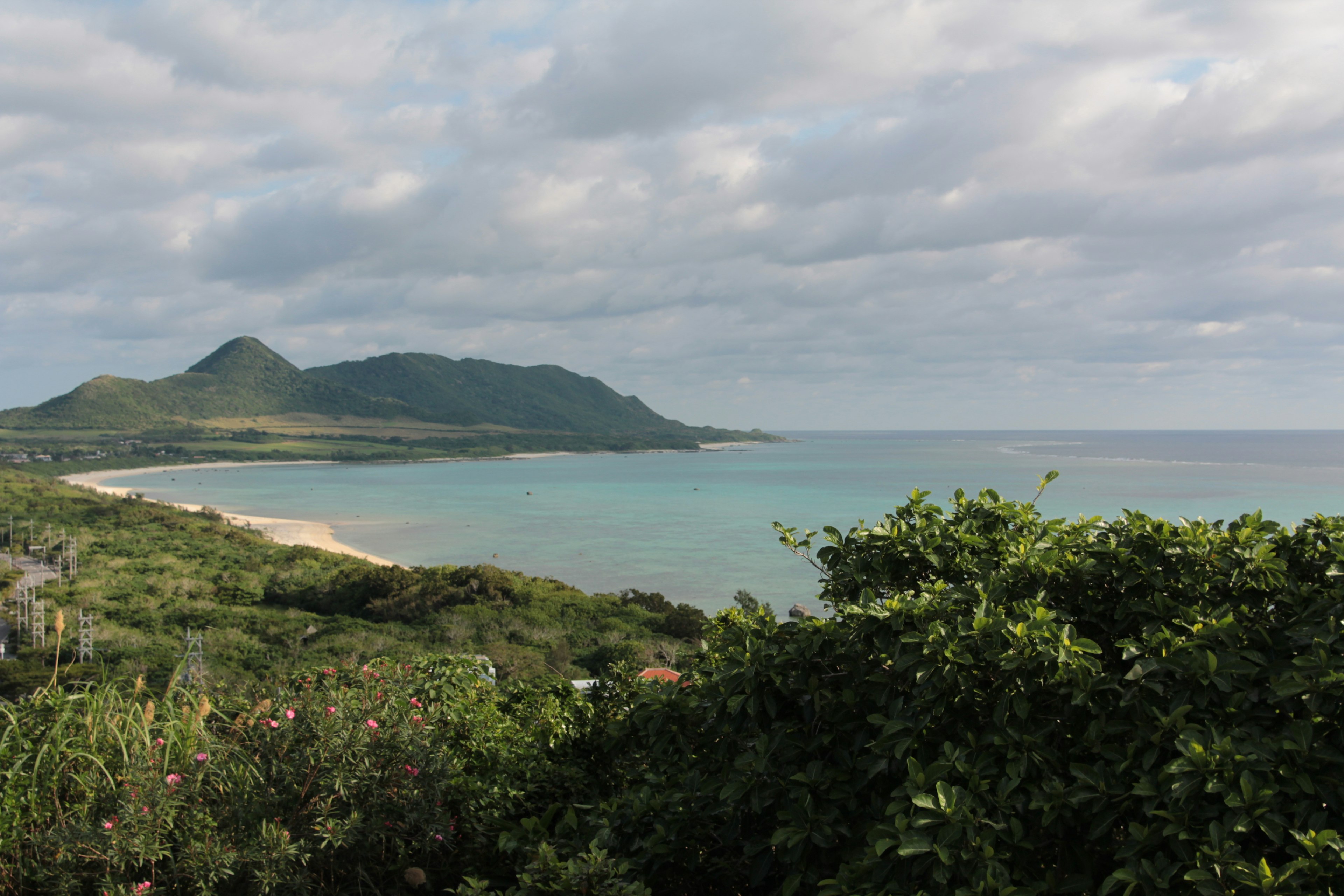 Garis pantai yang indah dengan bukit rimbun dan air tenang