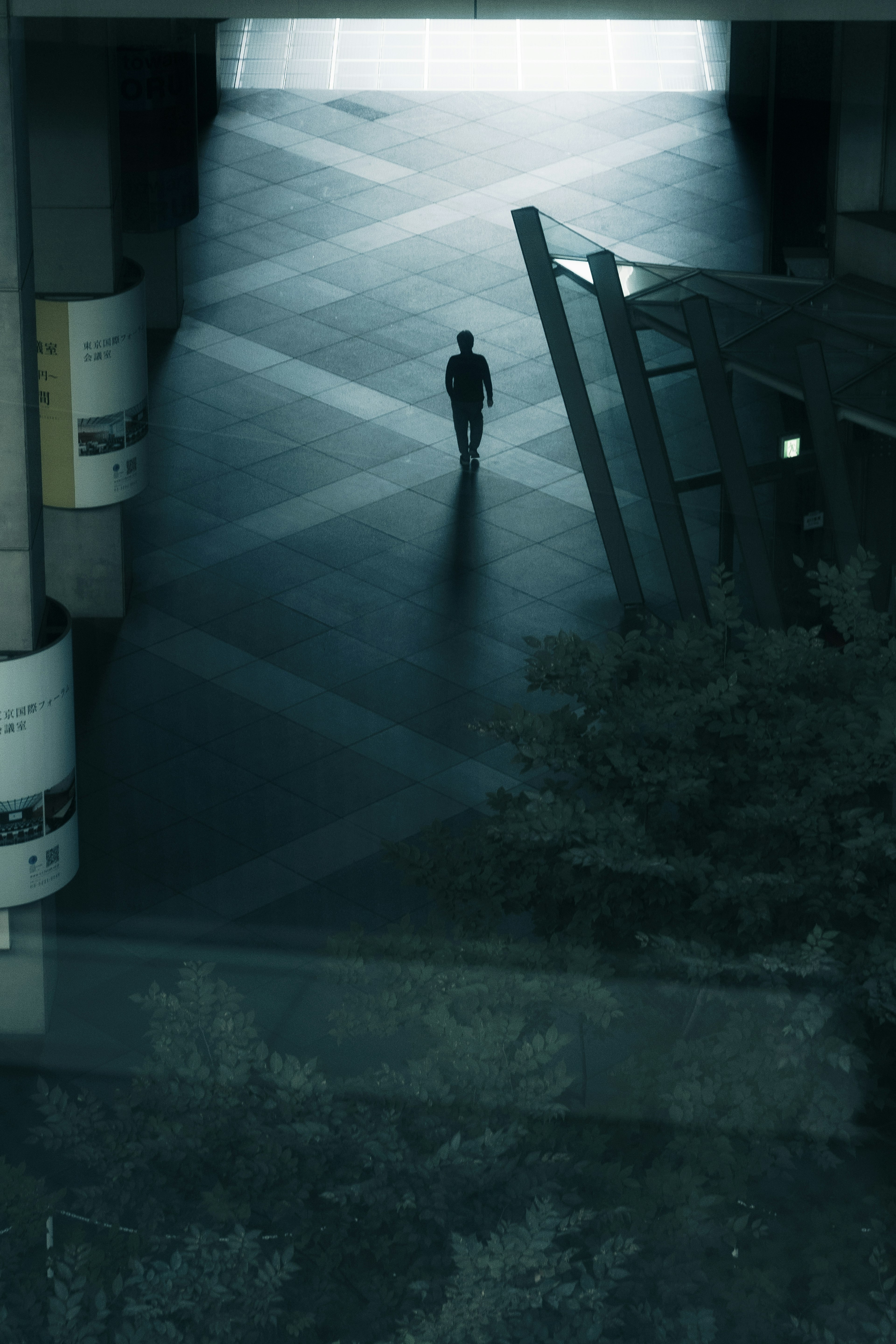 Silhouette di una persona in piedi in un ambiente poco illuminato