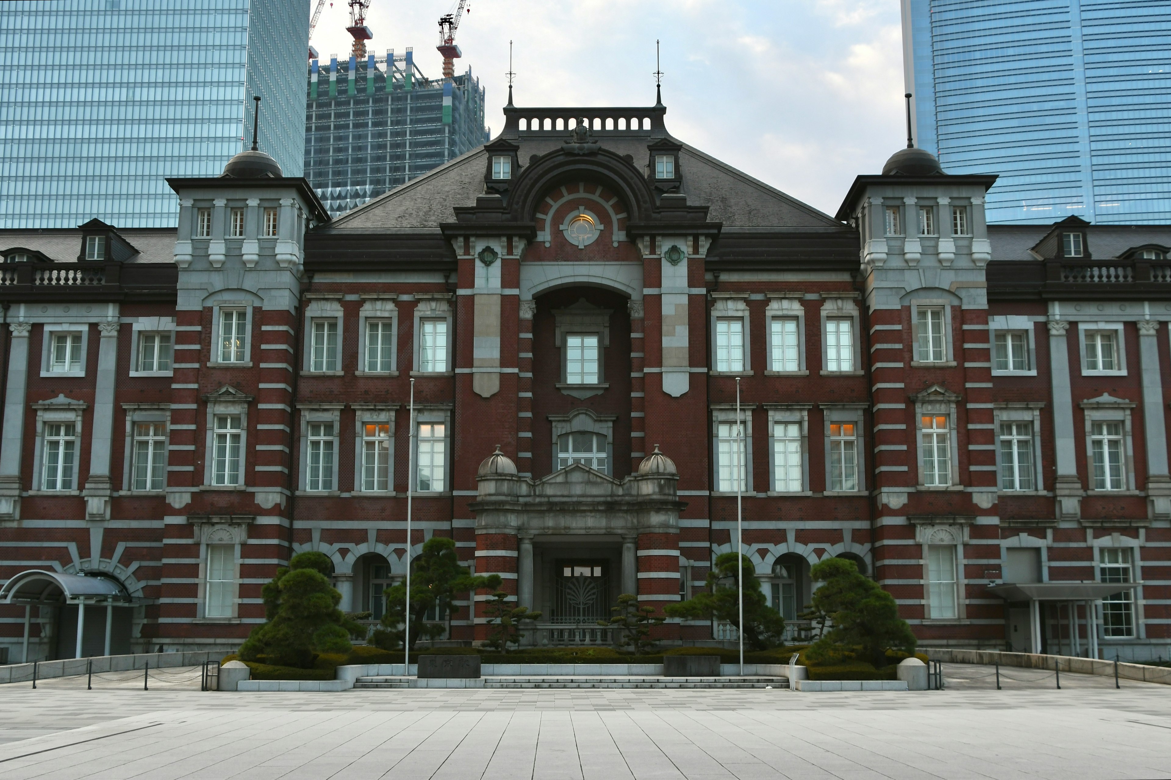 L'architecture en briques rouges de la gare de Tokyo contrastant avec les gratte-ciels modernes