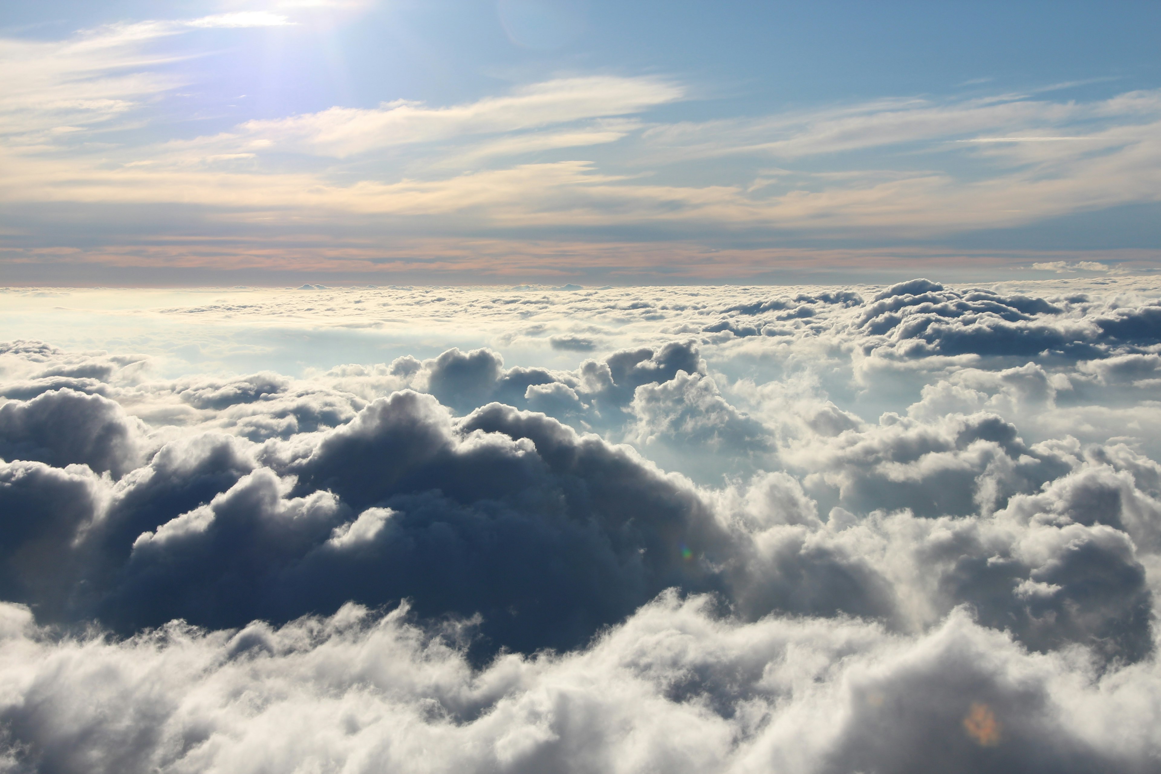 A sea of white clouds under a blue sky with sunlight