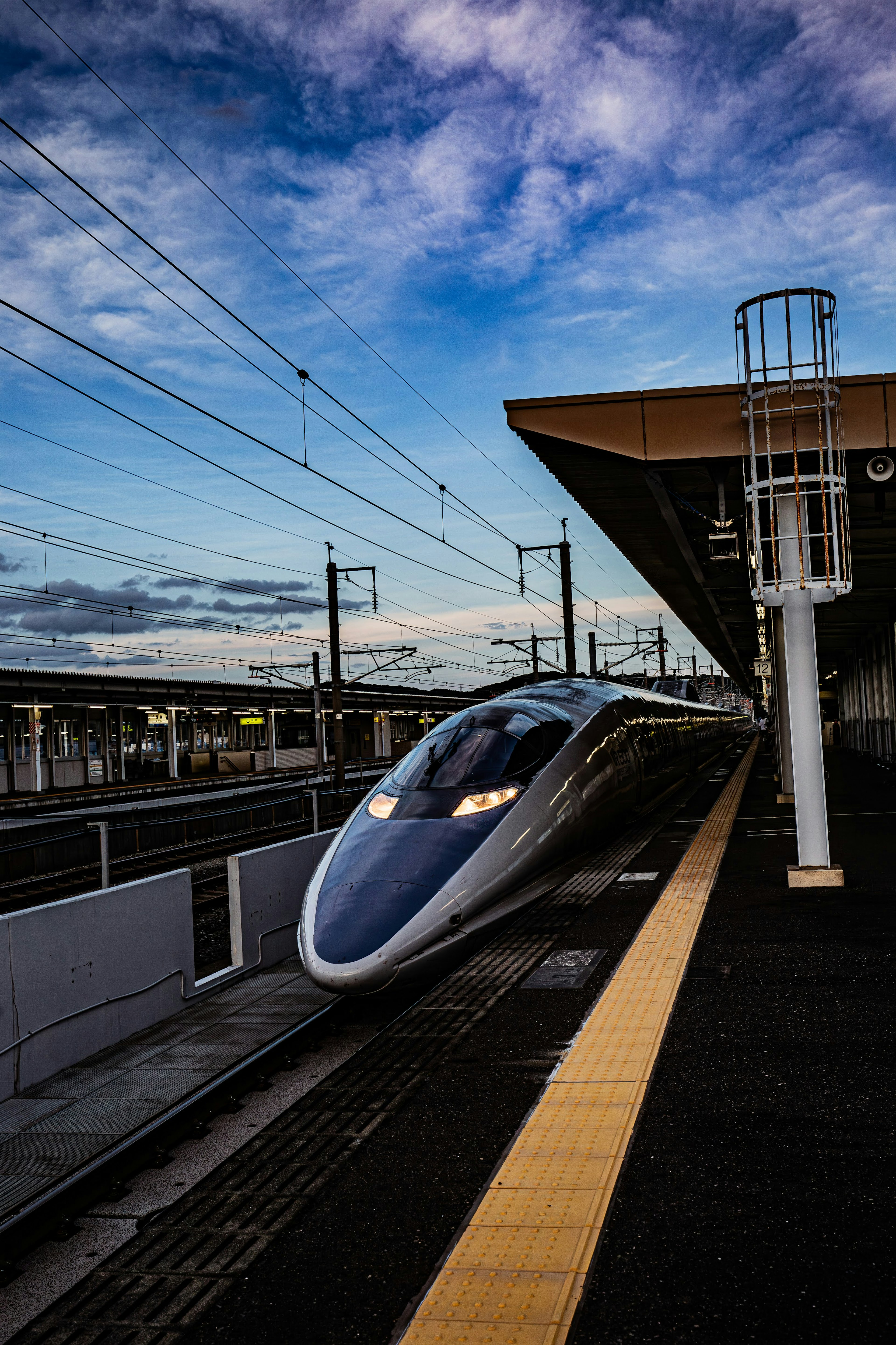 Shinkansen train at a station during twilight