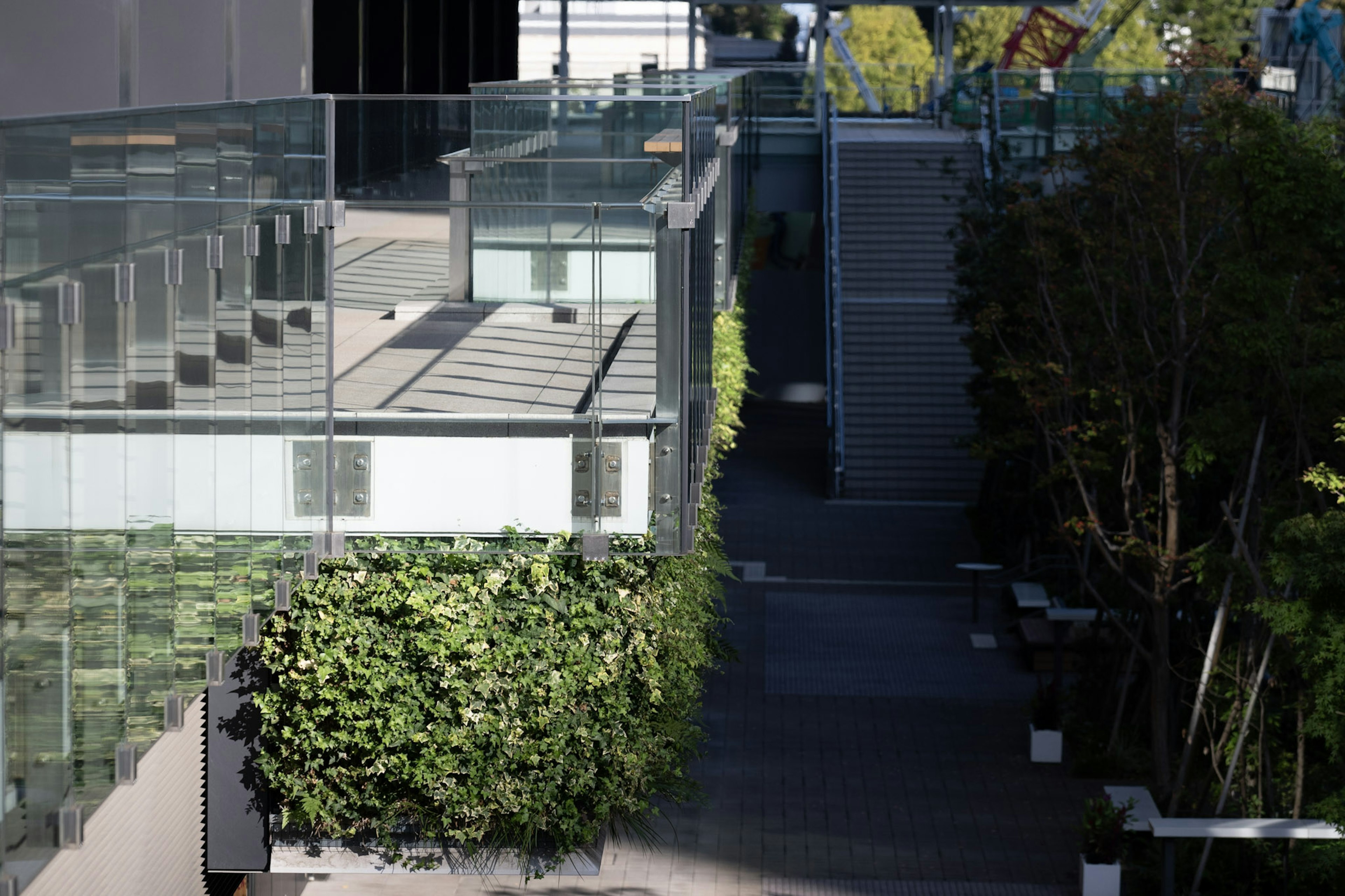 Extérieur moderne d'un bâtiment avec balcons en verre et aménagement paysager vert