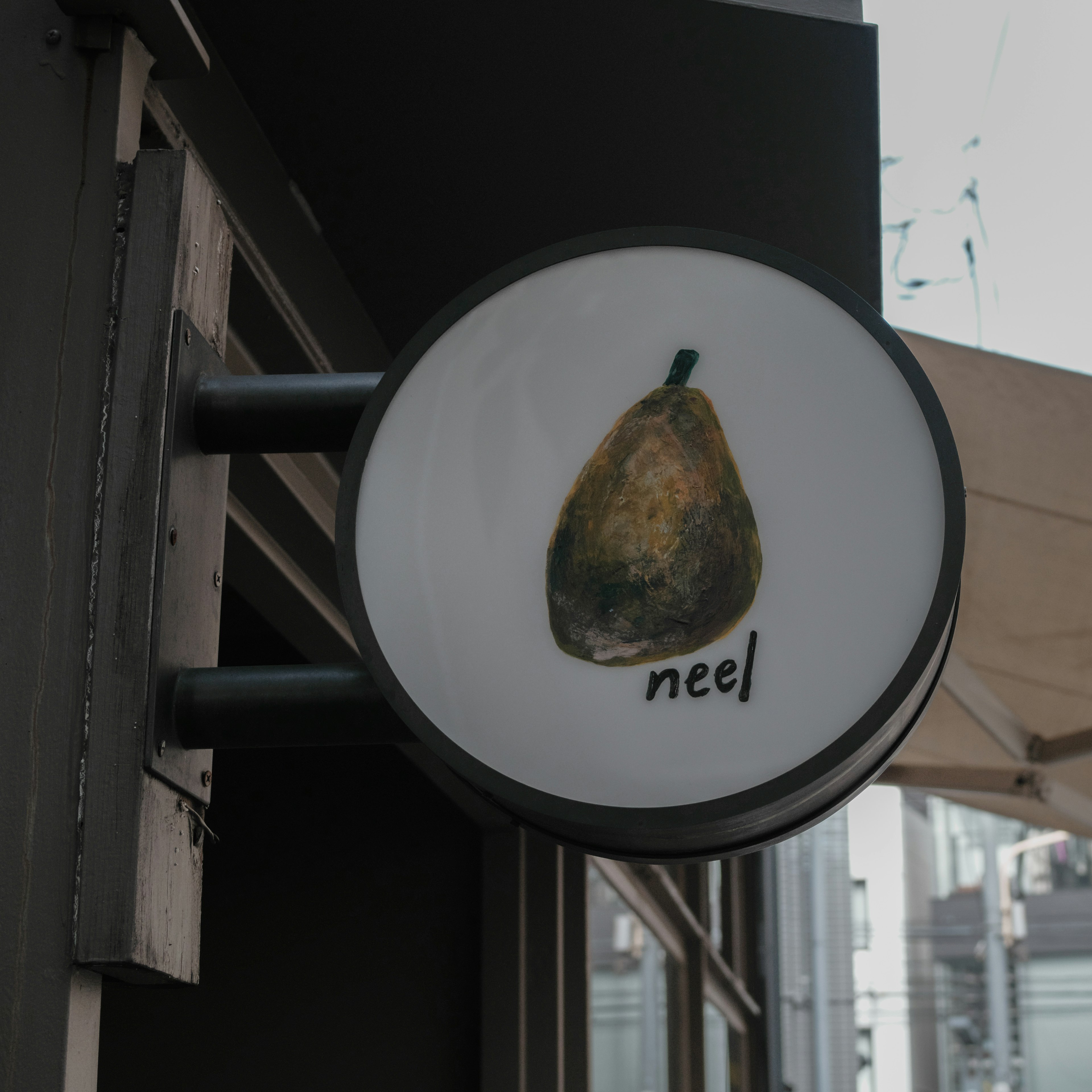 Signboard featuring a pear illustration and the word 'neel'