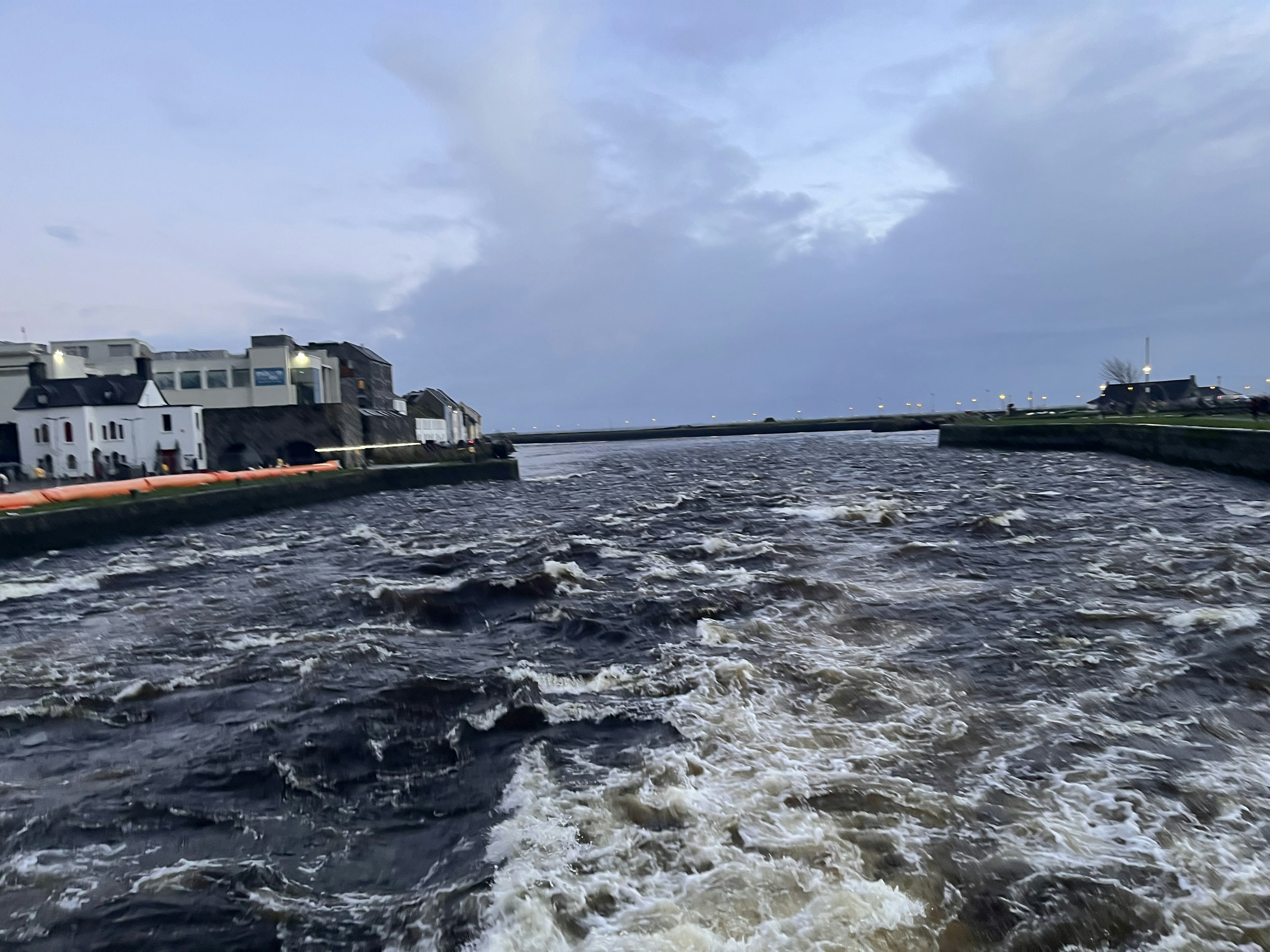 Vista de un río turbulento con edificios a lo largo de la costa