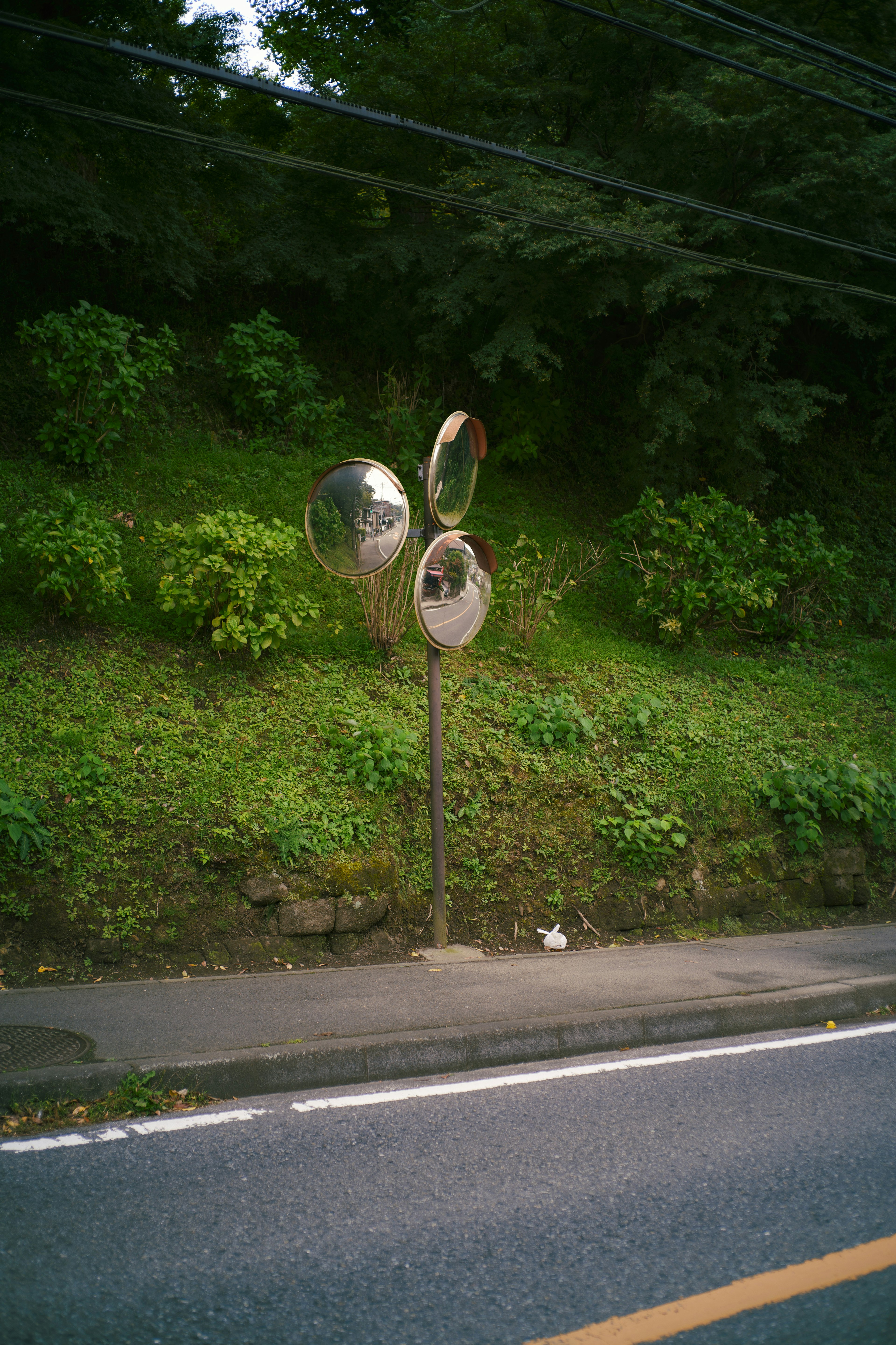 A striking sculpture featuring three silver spheres along the roadside