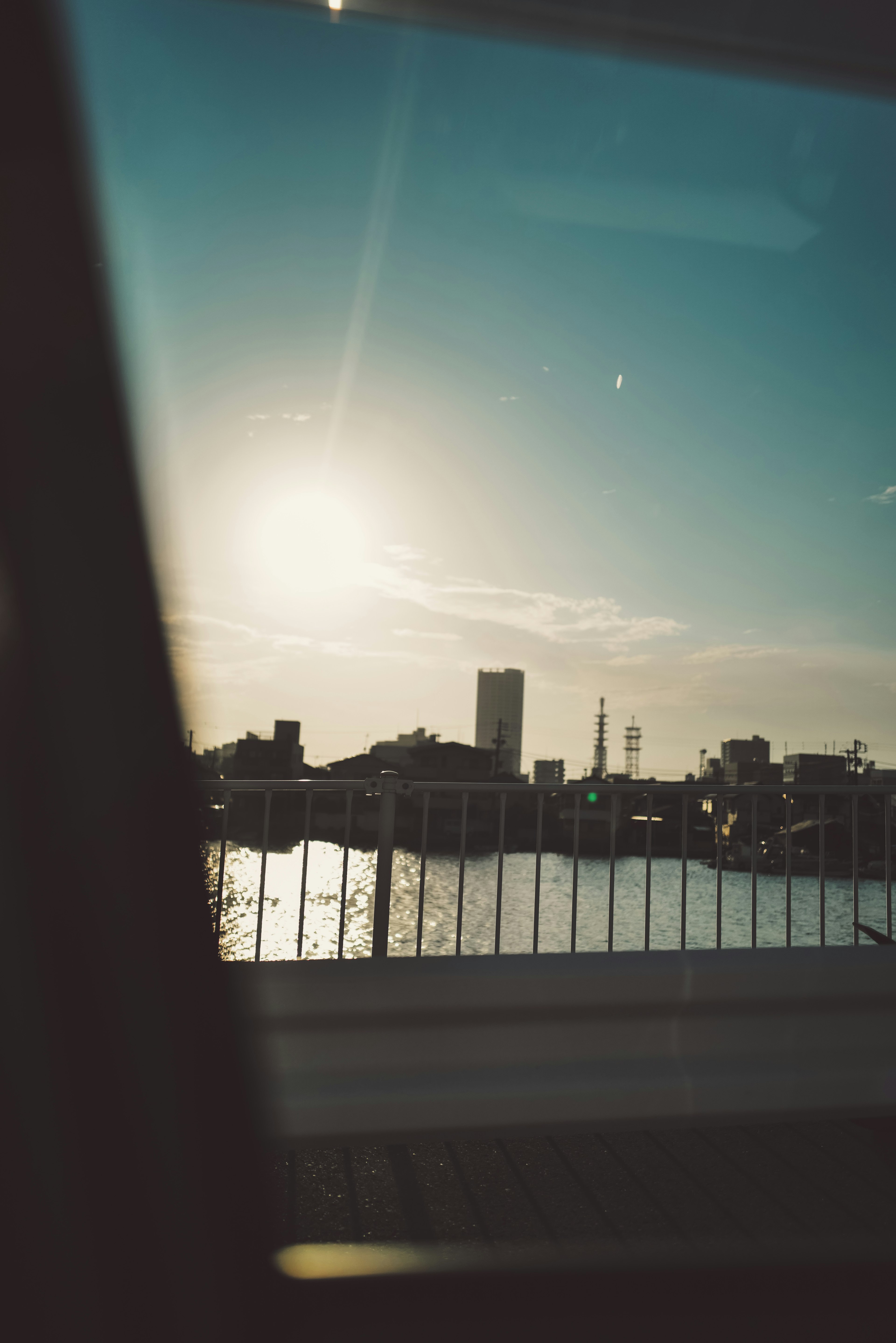 Silhouette de la ville avec reflet de coucher de soleil vu à travers une fenêtre