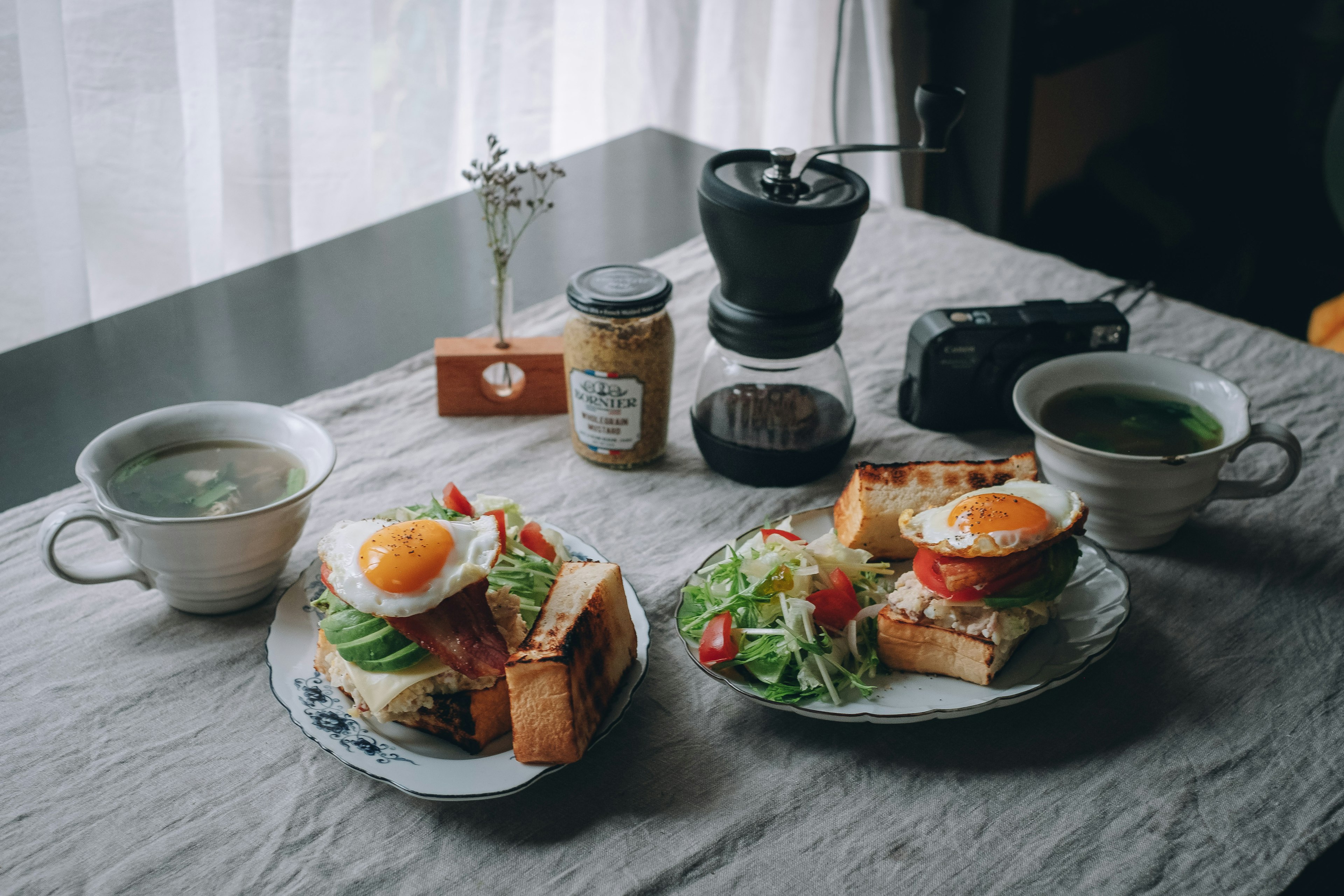 Piatti per la colazione con uova e insalata su un tavolo con bevande