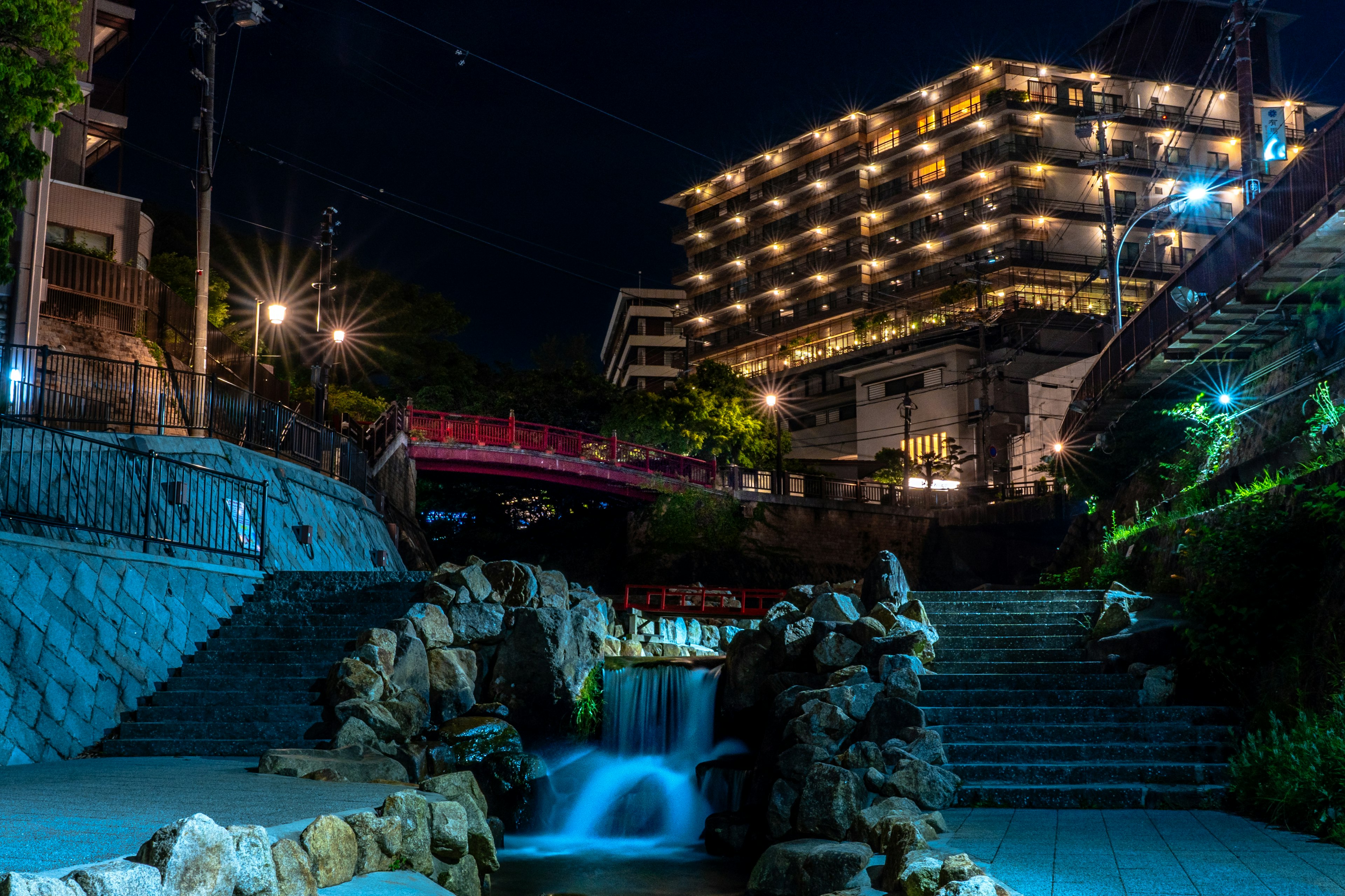 Scena notturna con una bella cascata e un edificio ben illuminato