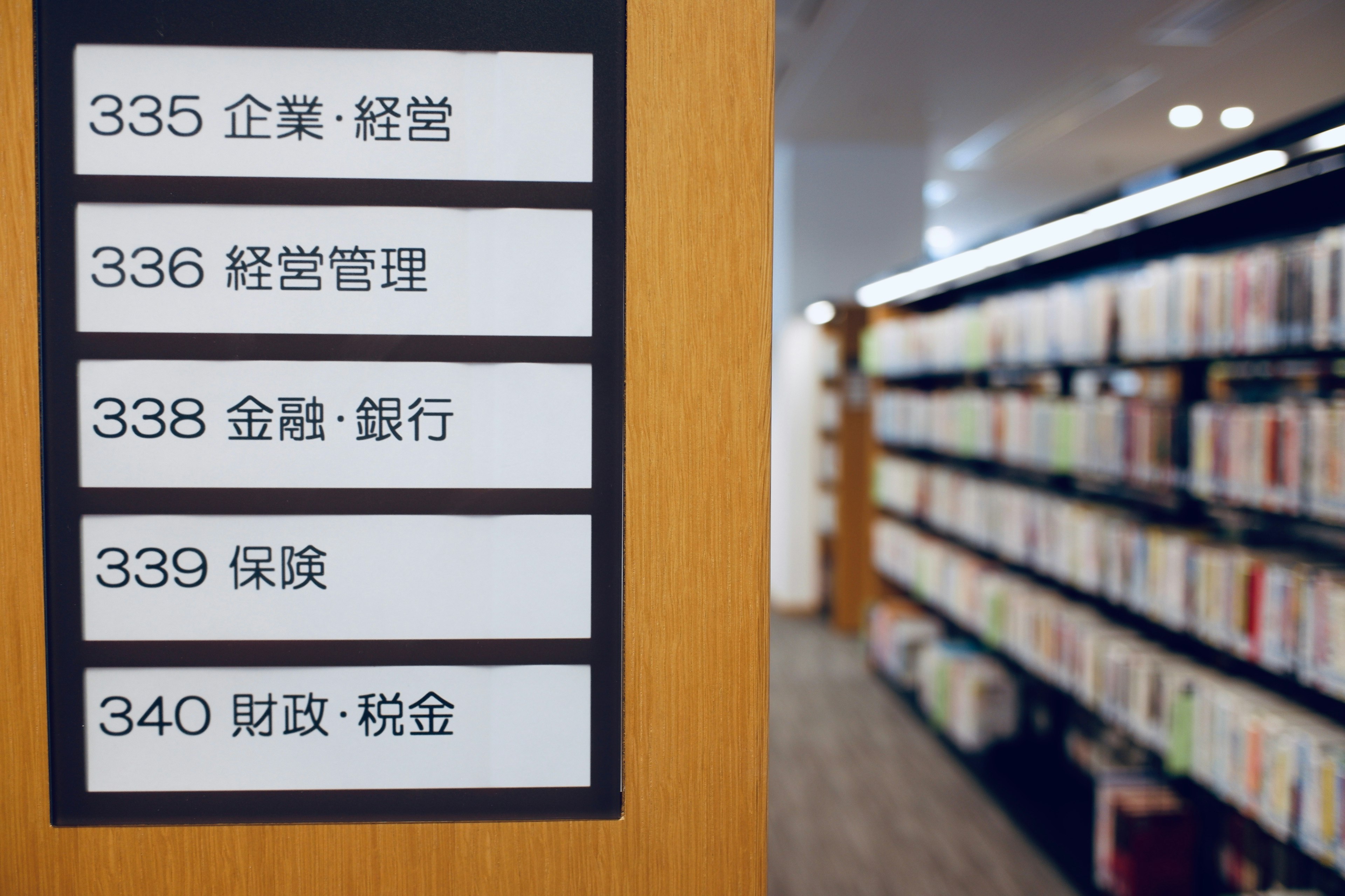 図書館の本棚と分類番号のサインが表示されている