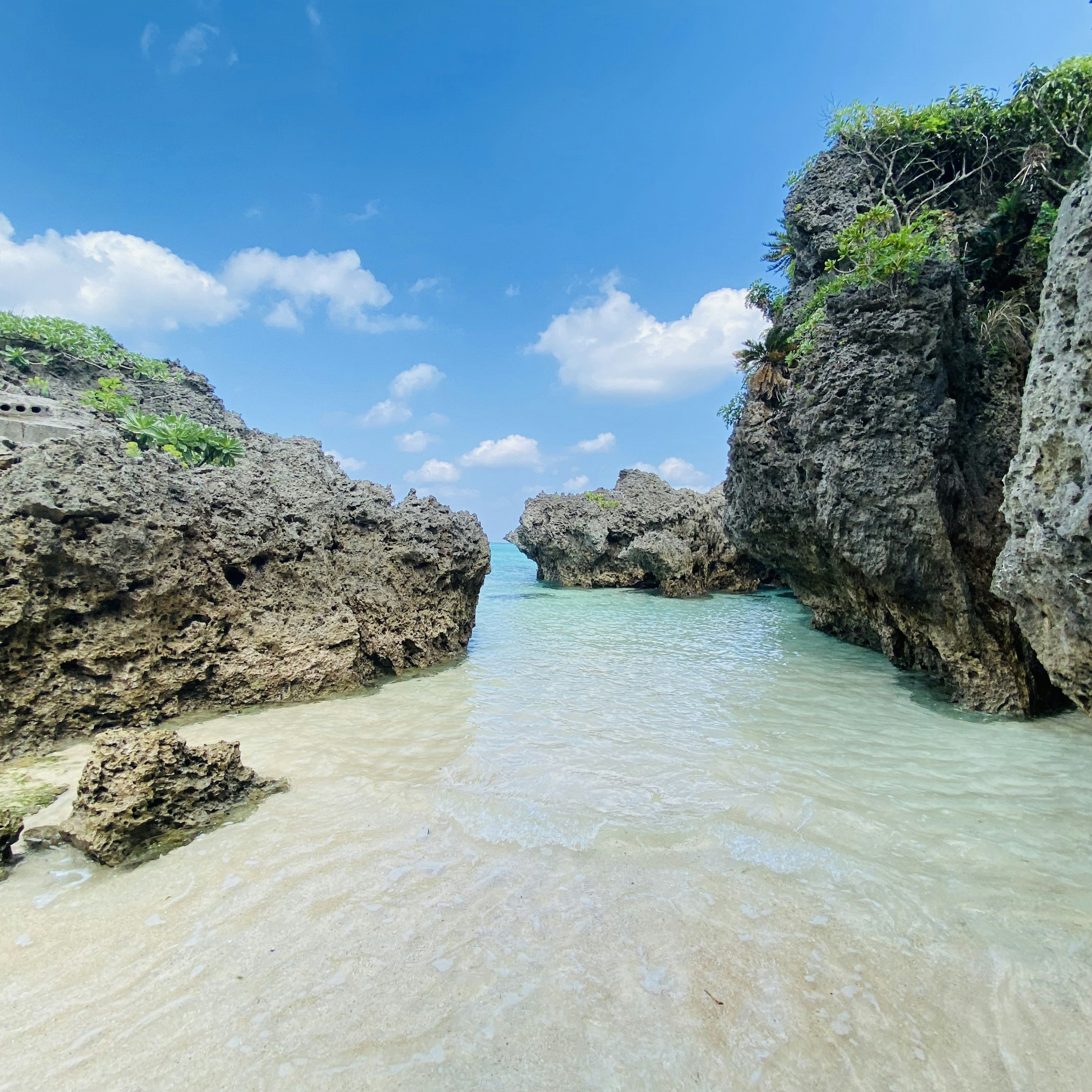 Vue de plage sereine entourée de rochers et ciel bleu clair