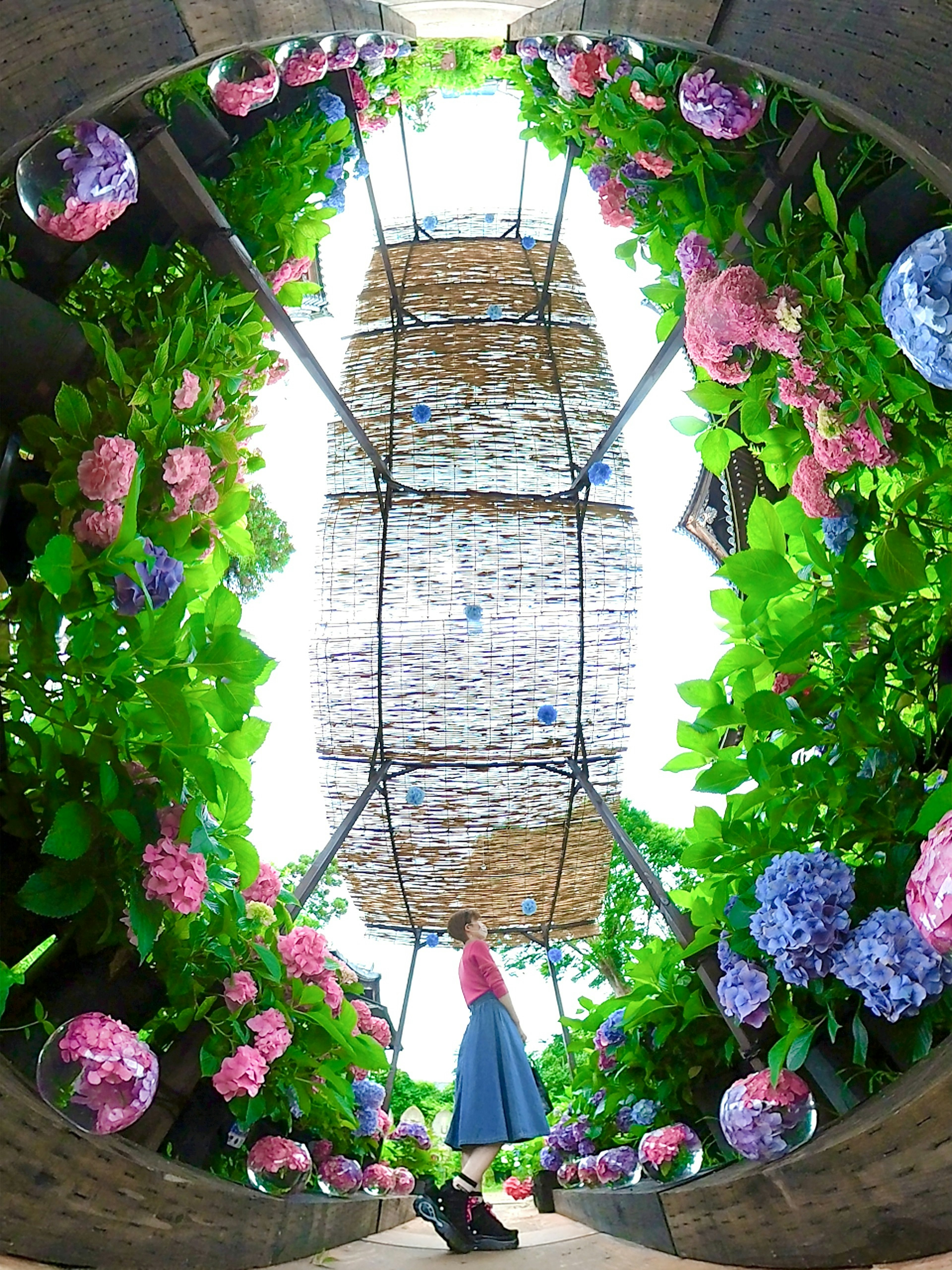 Una mujer de pie rodeada de hermosas flores