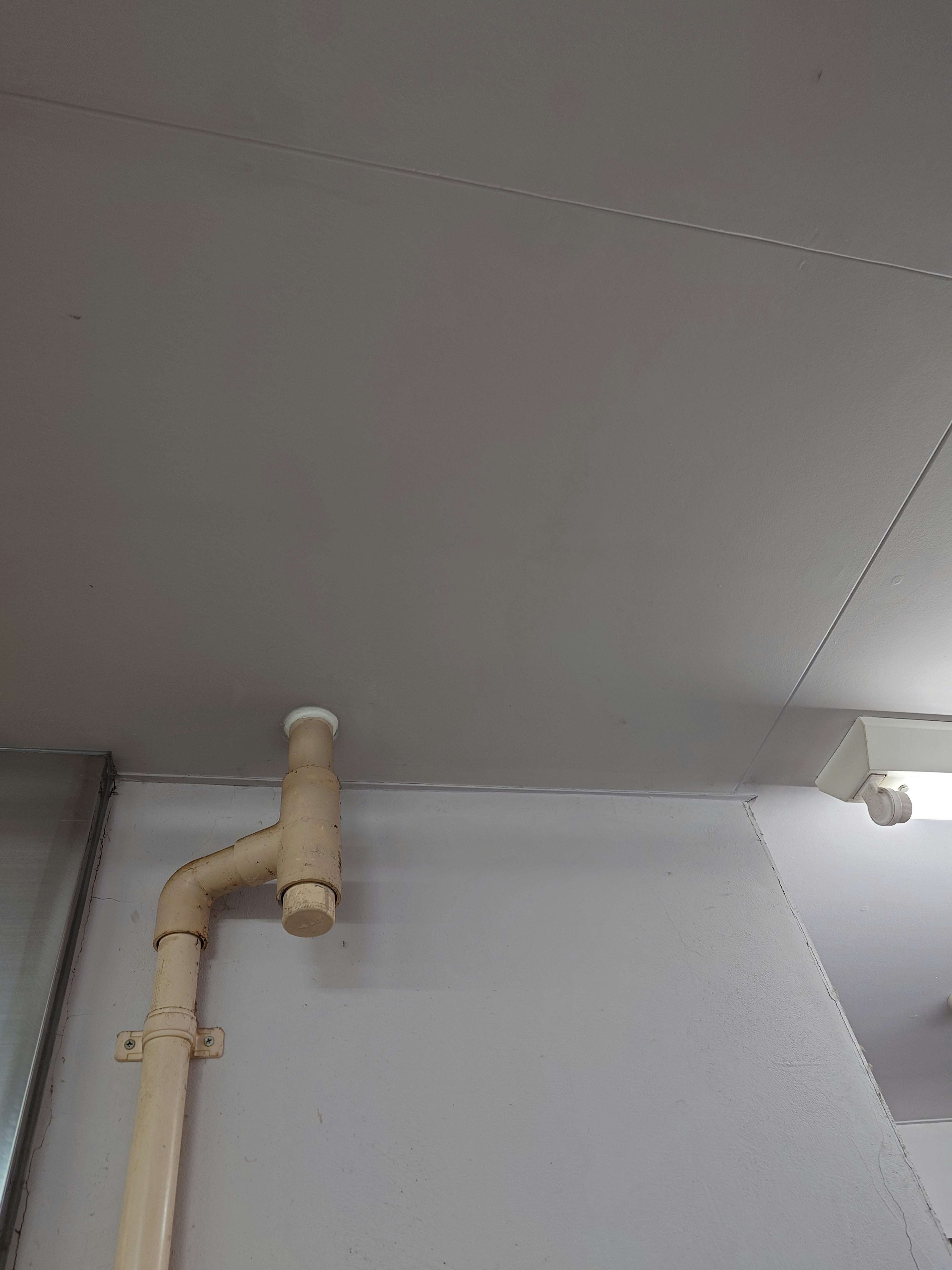 Simple interior view featuring a ceiling pipe and light fixture