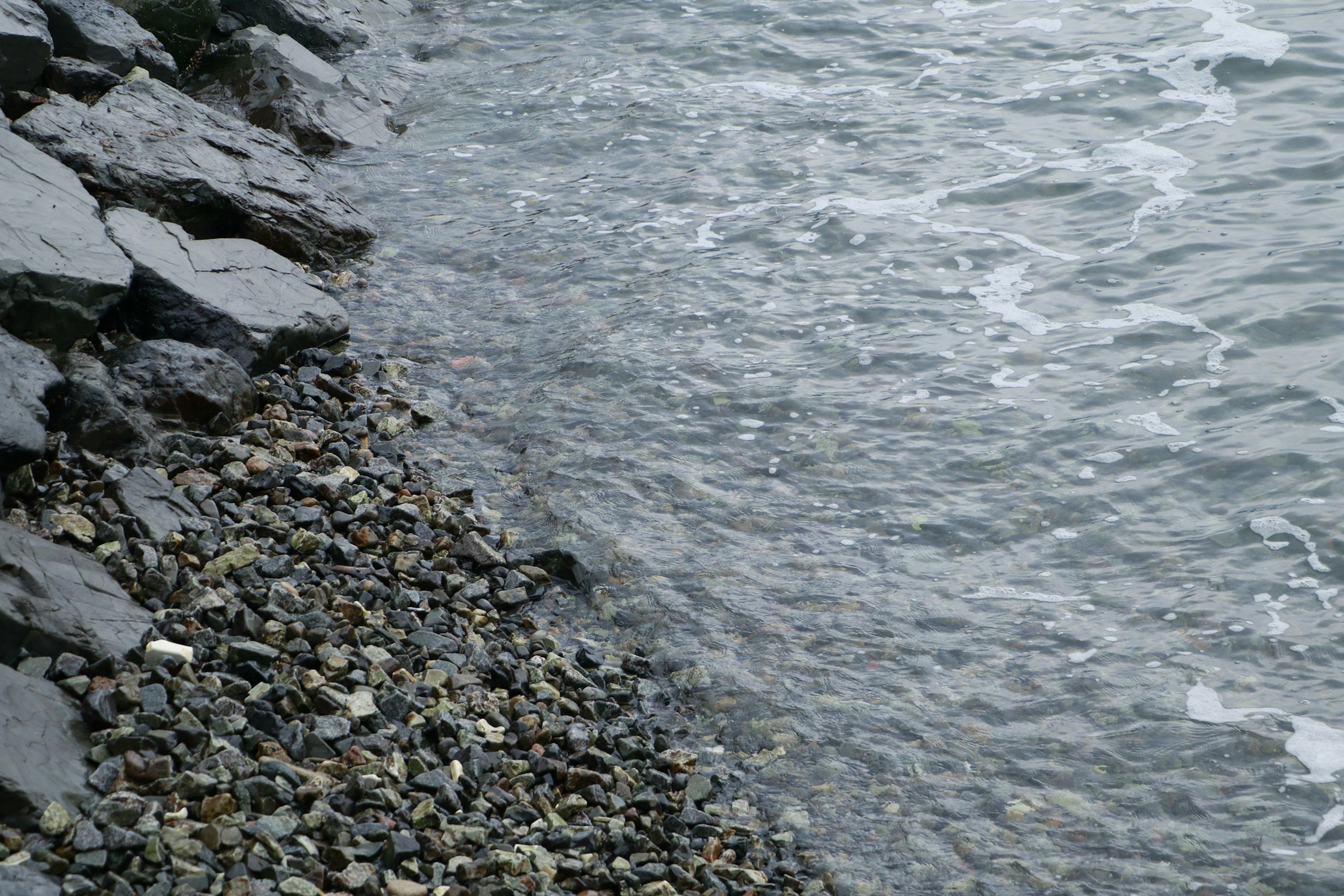 Coastal view featuring rocks and gentle waves