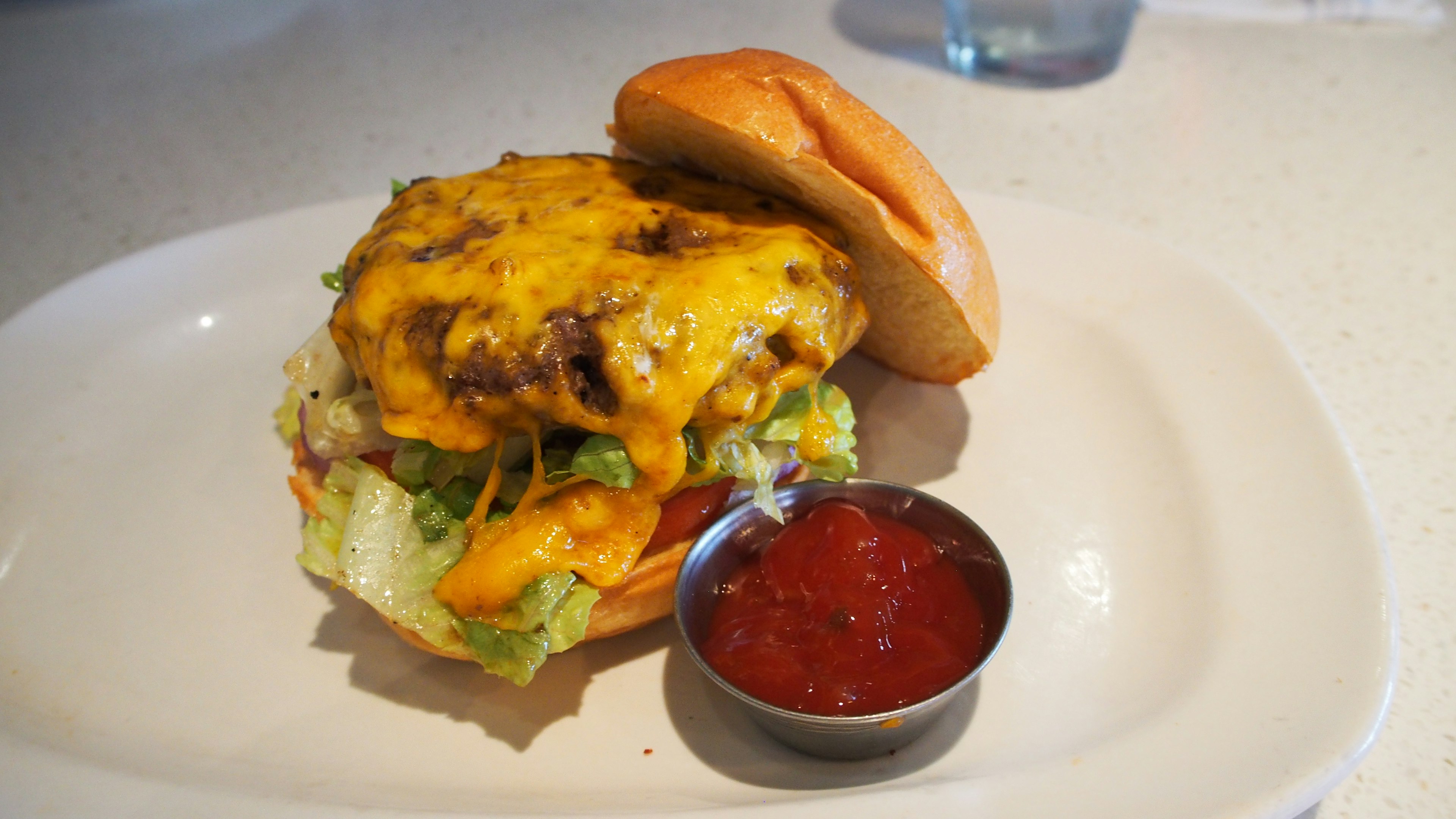 Hamburger au fromage avec de la laitue et un accompagnement de ketchup