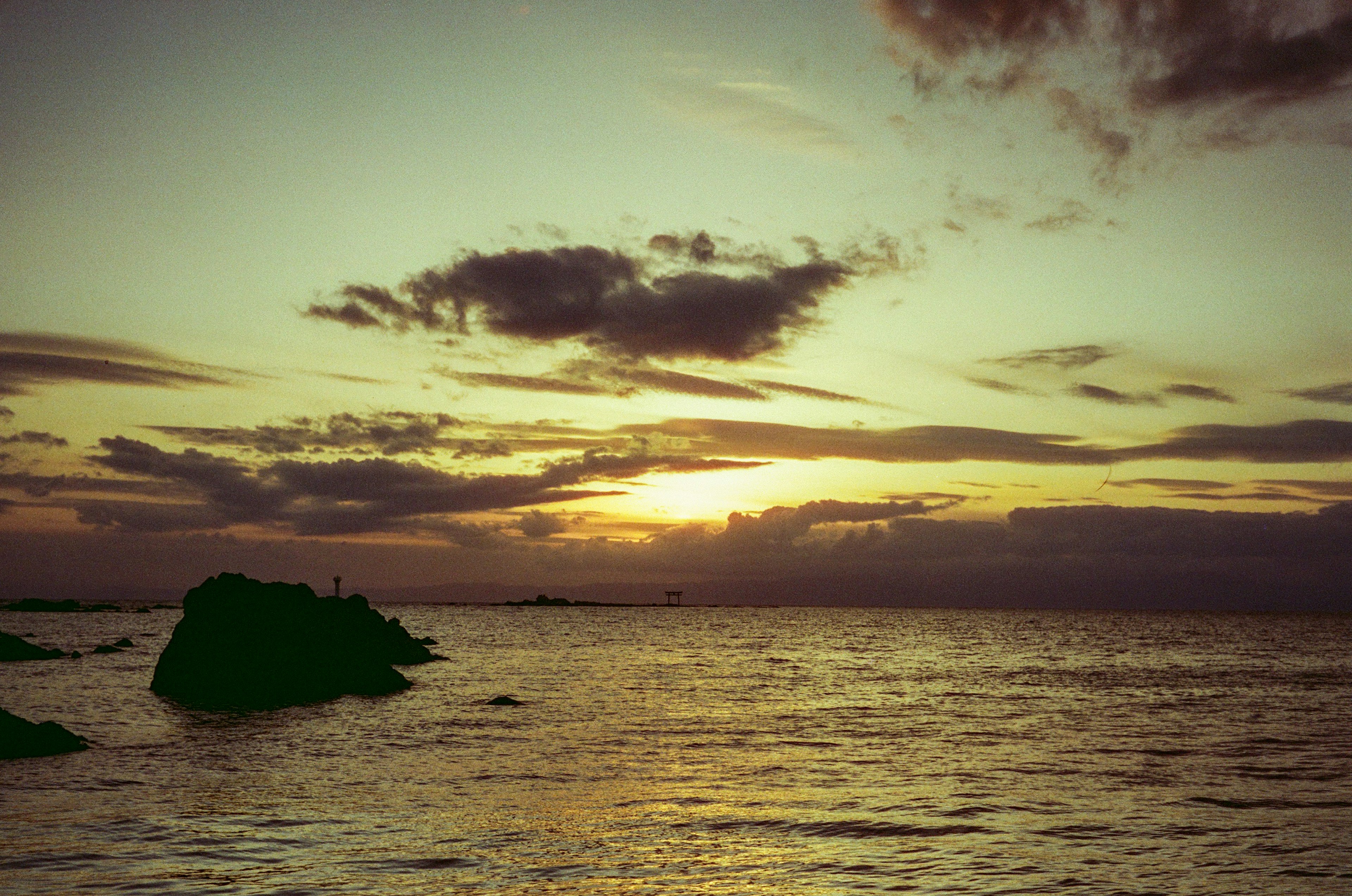 Scenografico tramonto sull'oceano con rocce e cielo vibrante arancione e viola