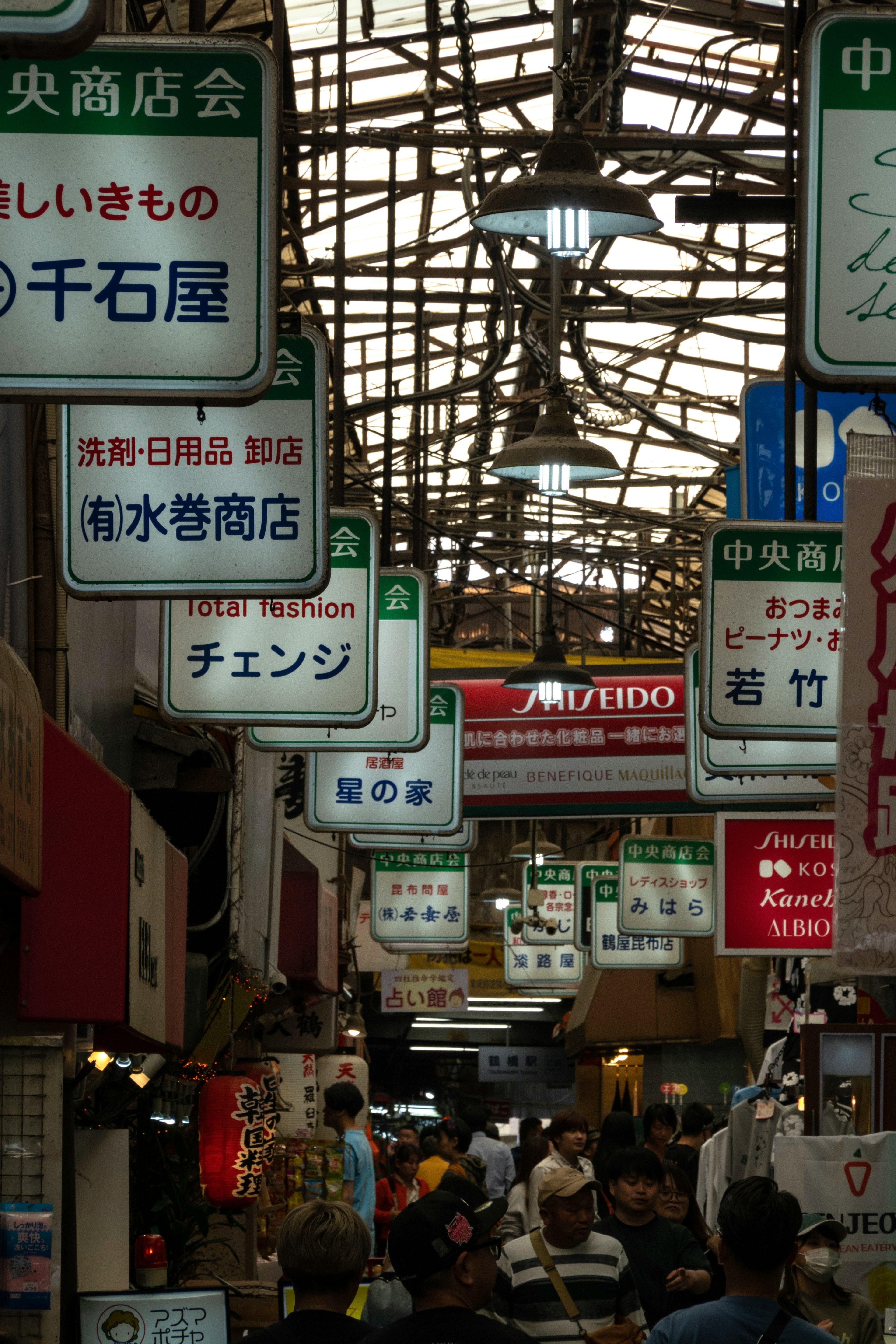 屋根付き商店街の賑やかな通りに並ぶ商店の看板