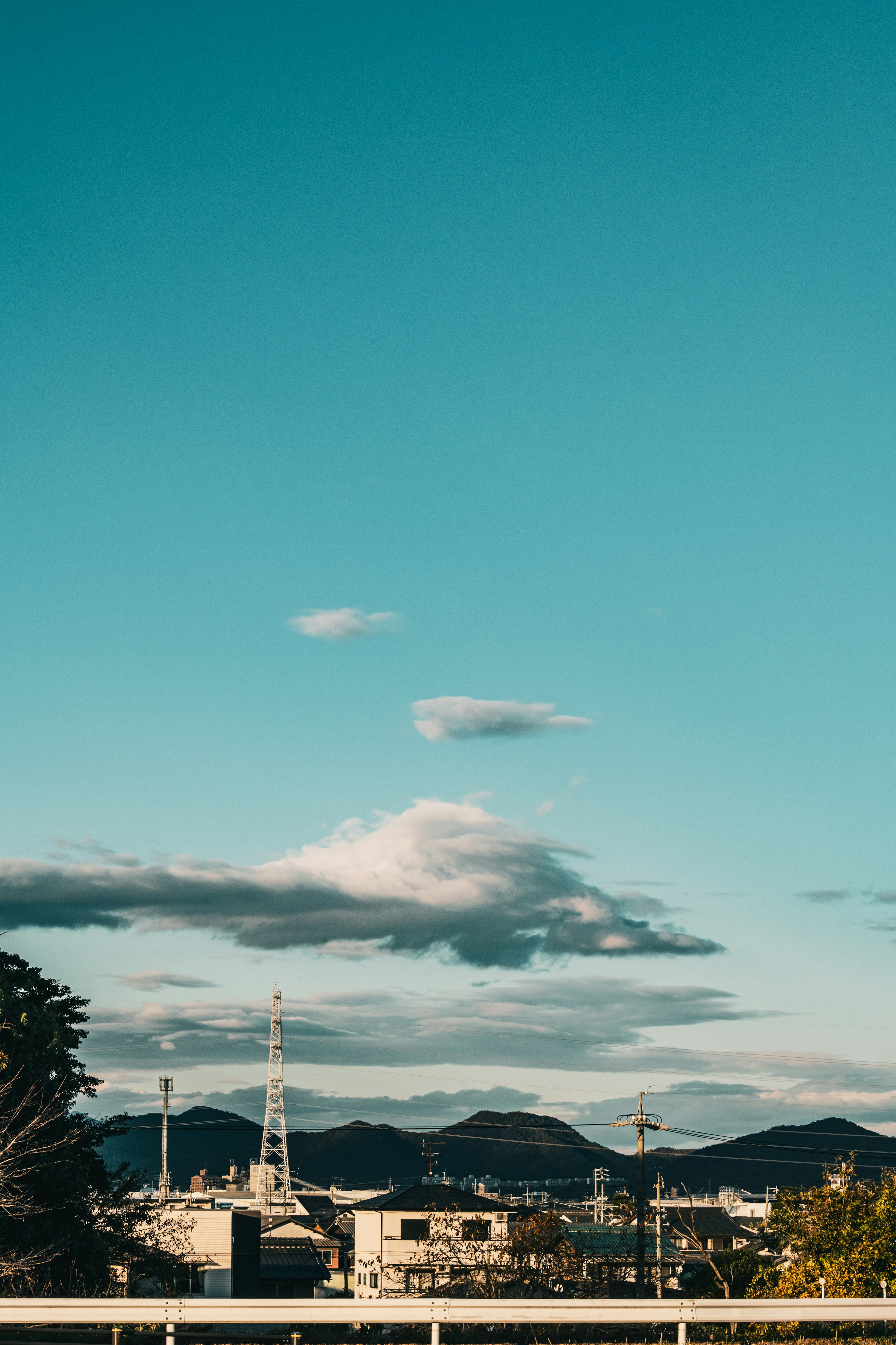 Paisaje con cielo azul y nubes que presenta montañas y silueta de la ciudad