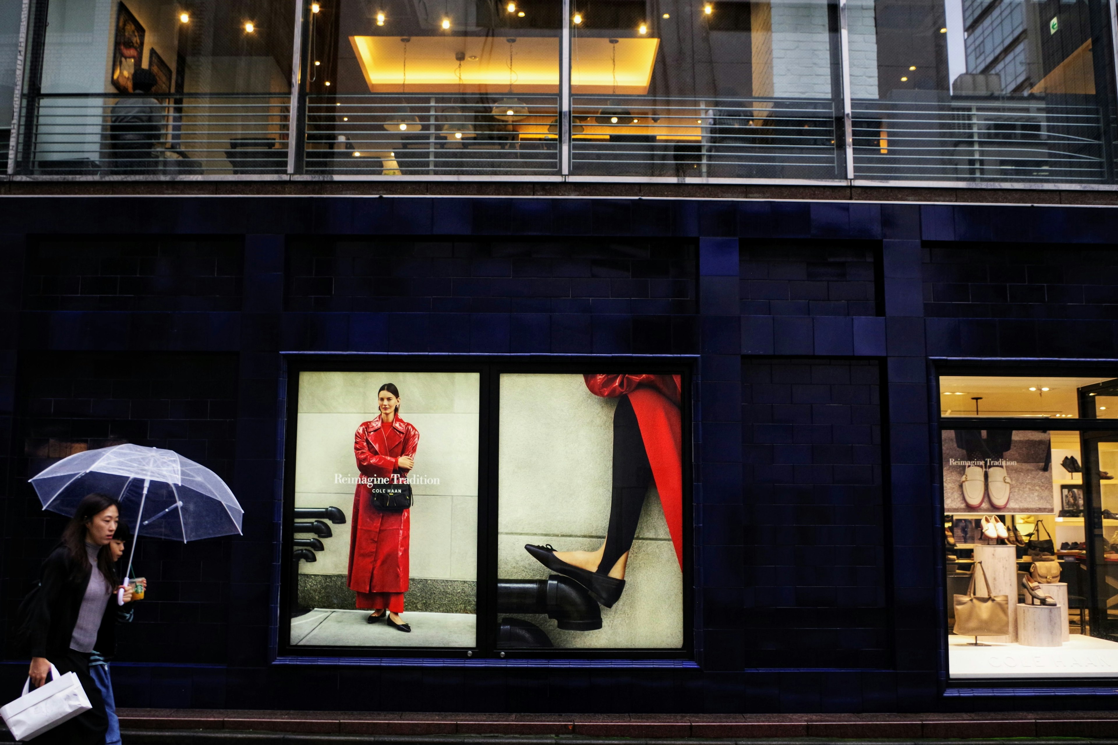 Scène de rue en ville présentant un modèle en robe rouge dans une vitrine