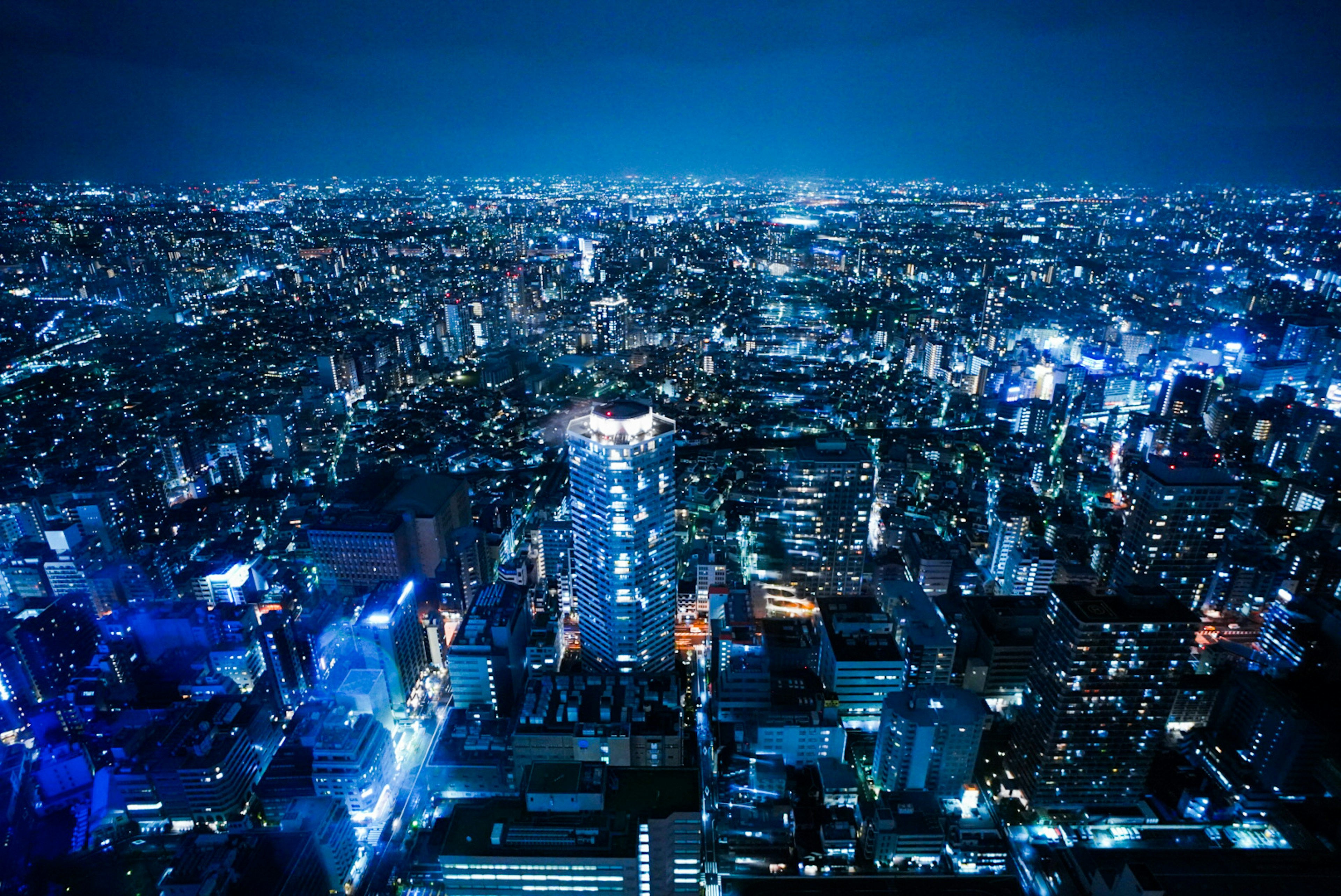 Vasta vista urbana di Tokyo di notte illuminata da luci blu