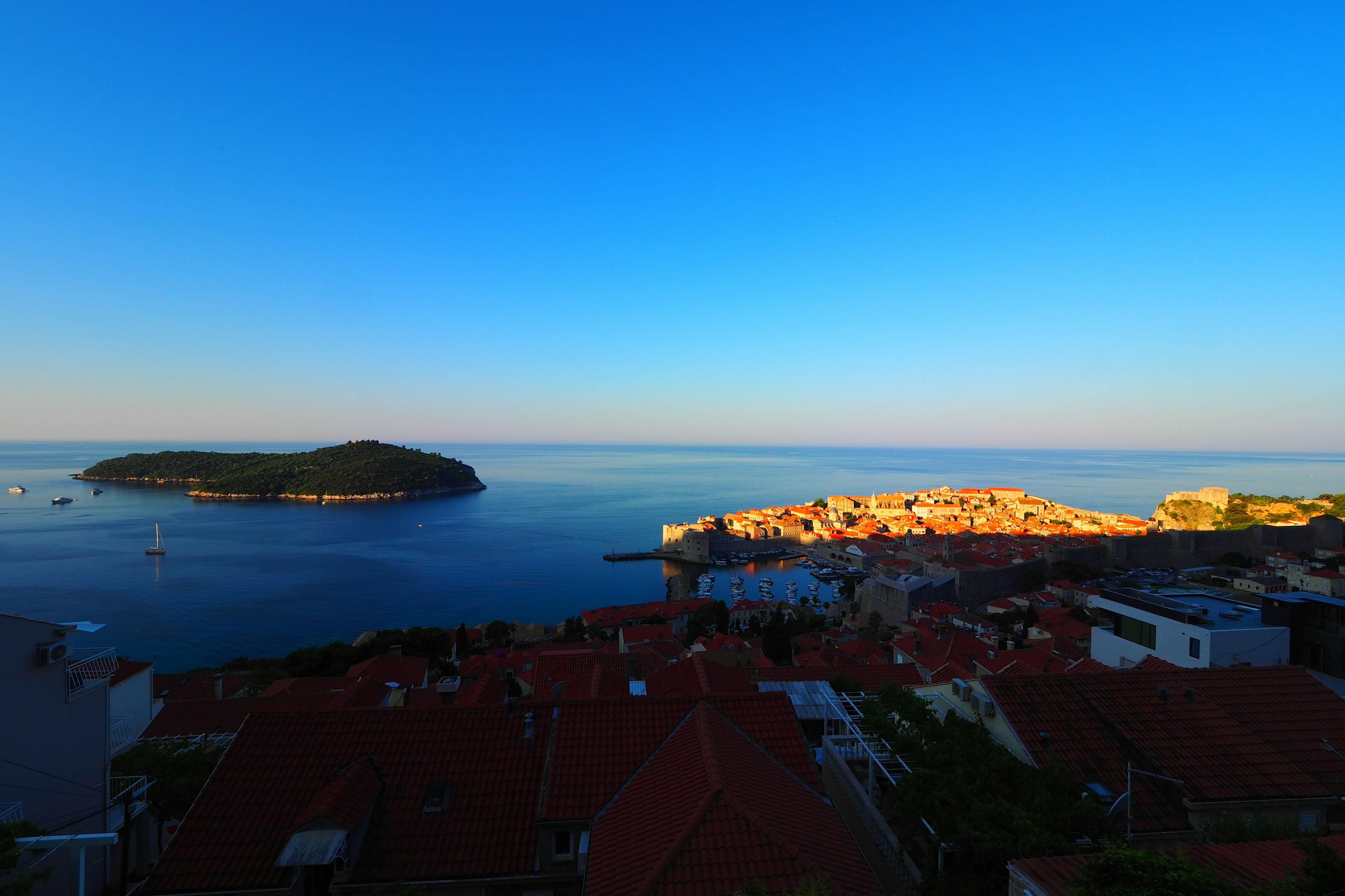 Vue côtière avec un ciel bleu et une mer tranquille avec une île