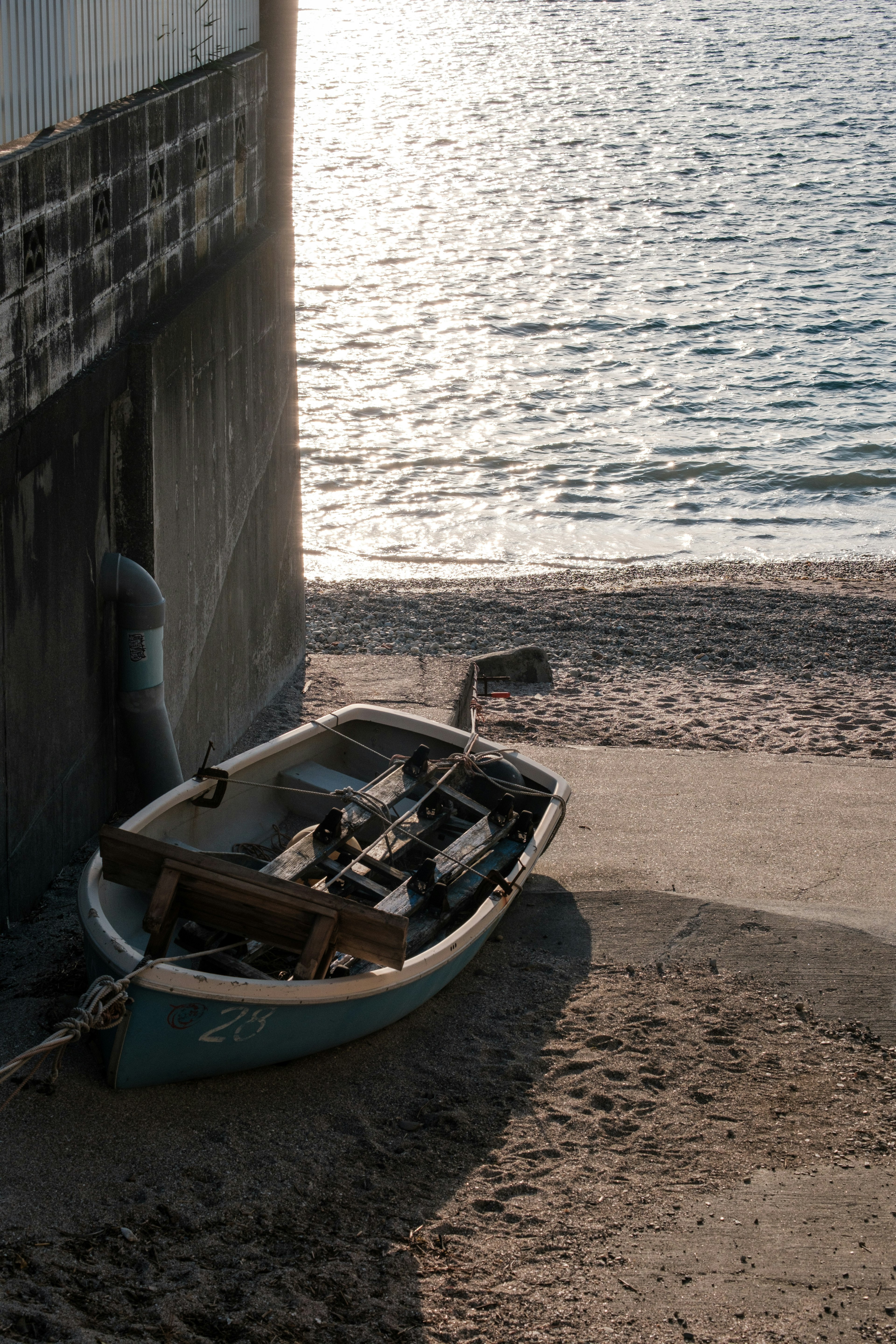 Ein kleines Boot, das am Sandstrand bei ruhigem Wasser ruht