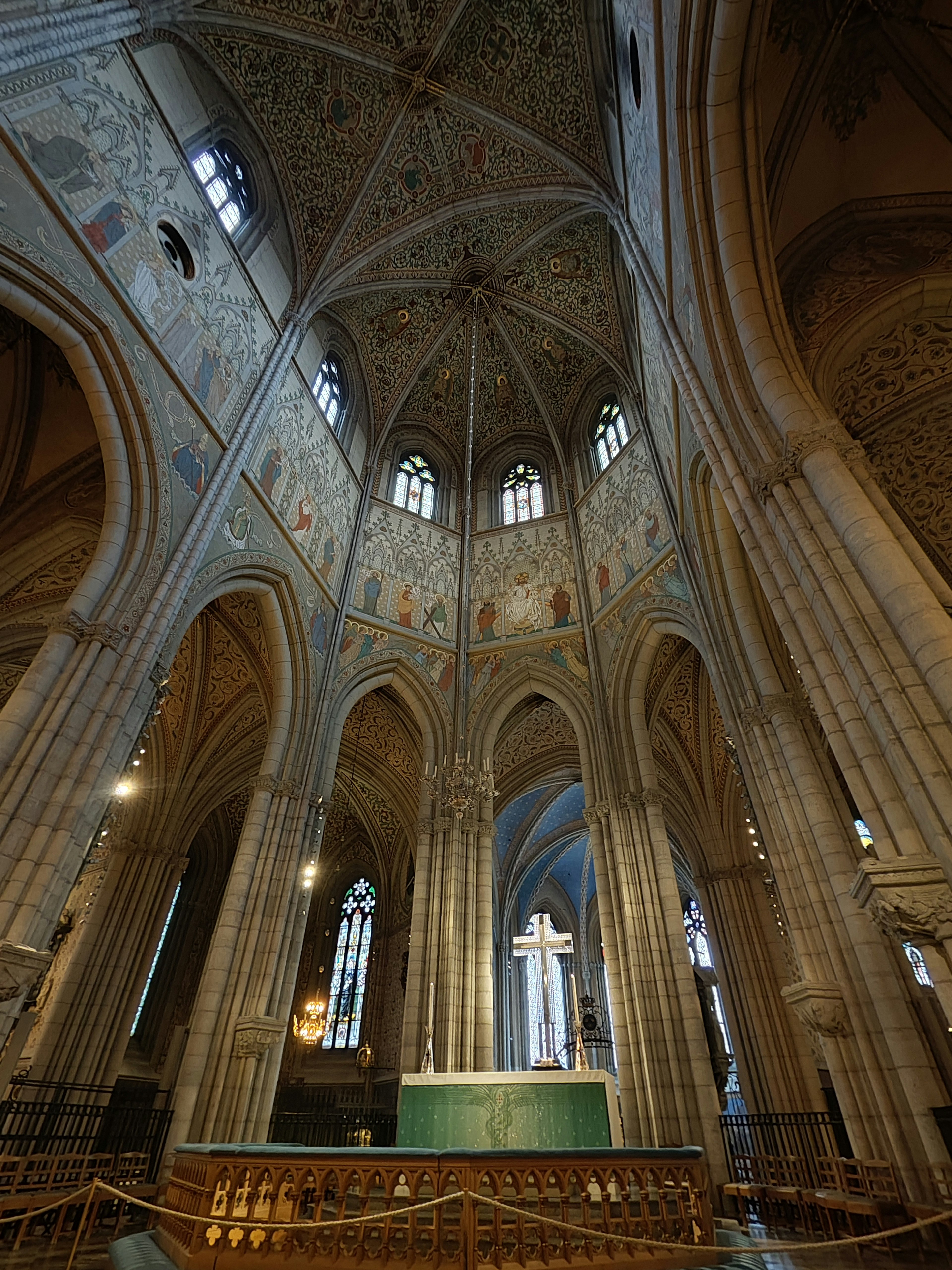 Interior de una iglesia impresionante con techos altos y arcos y murales coloridos con un altar central de cruz