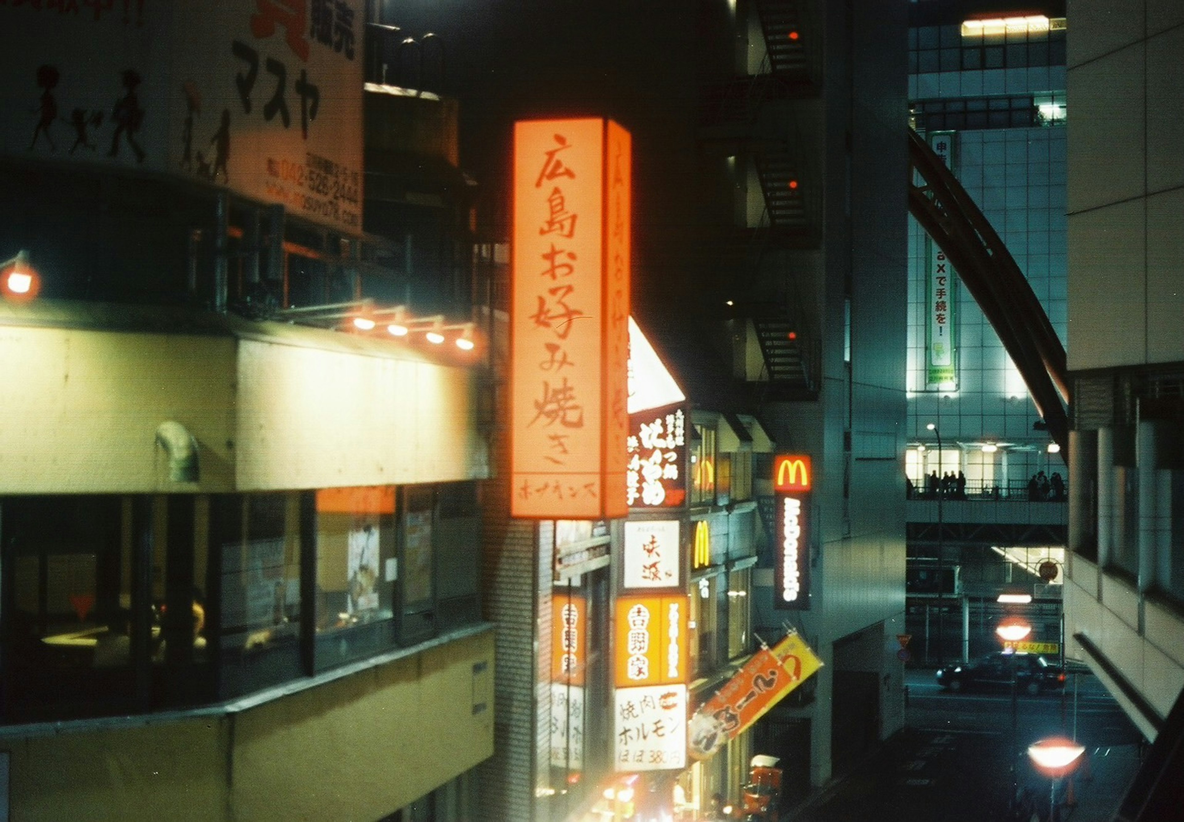 Restaurant signage in a nighttime urban setting with McDonald's logo