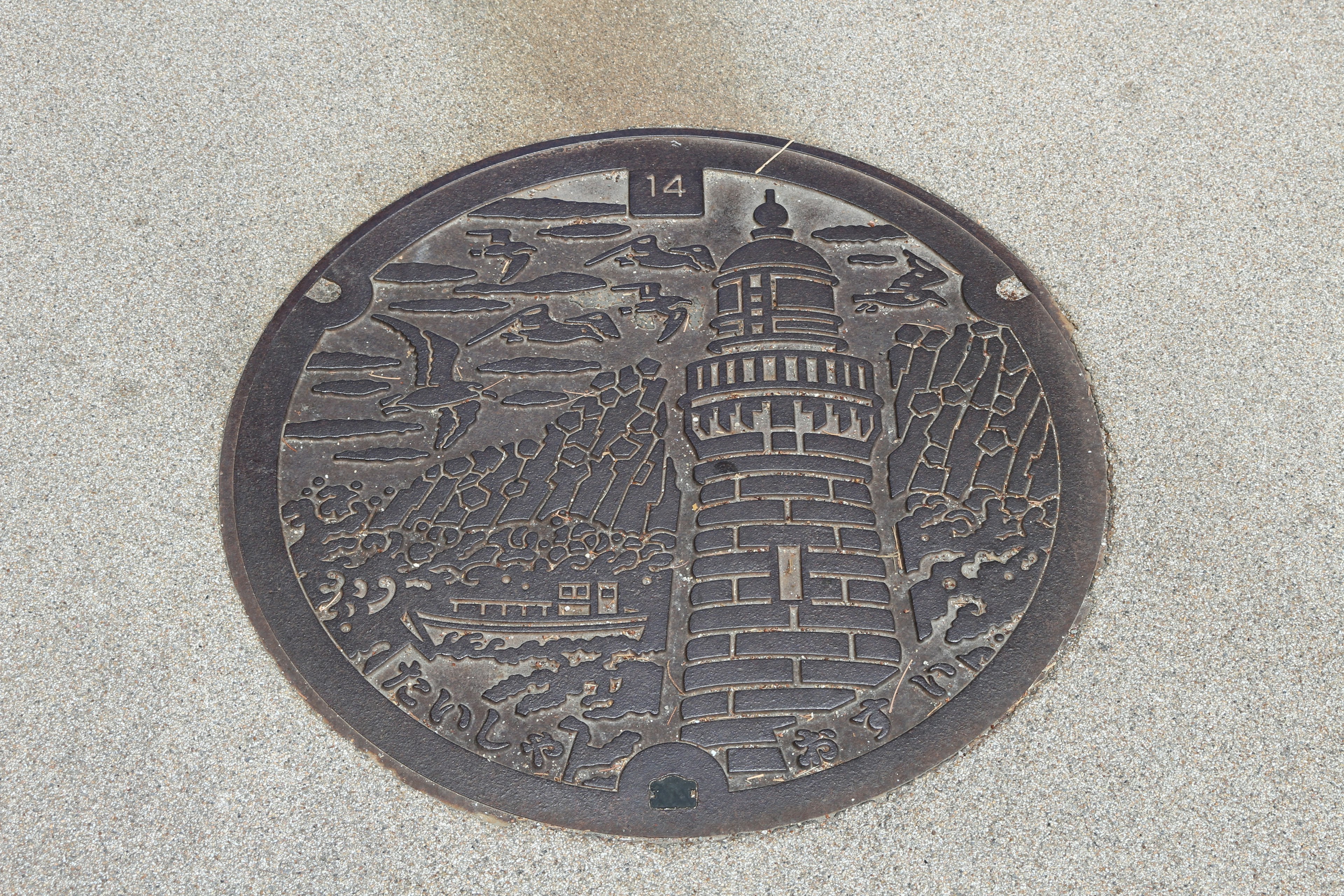 Image of a manhole cover featuring a lighthouse design