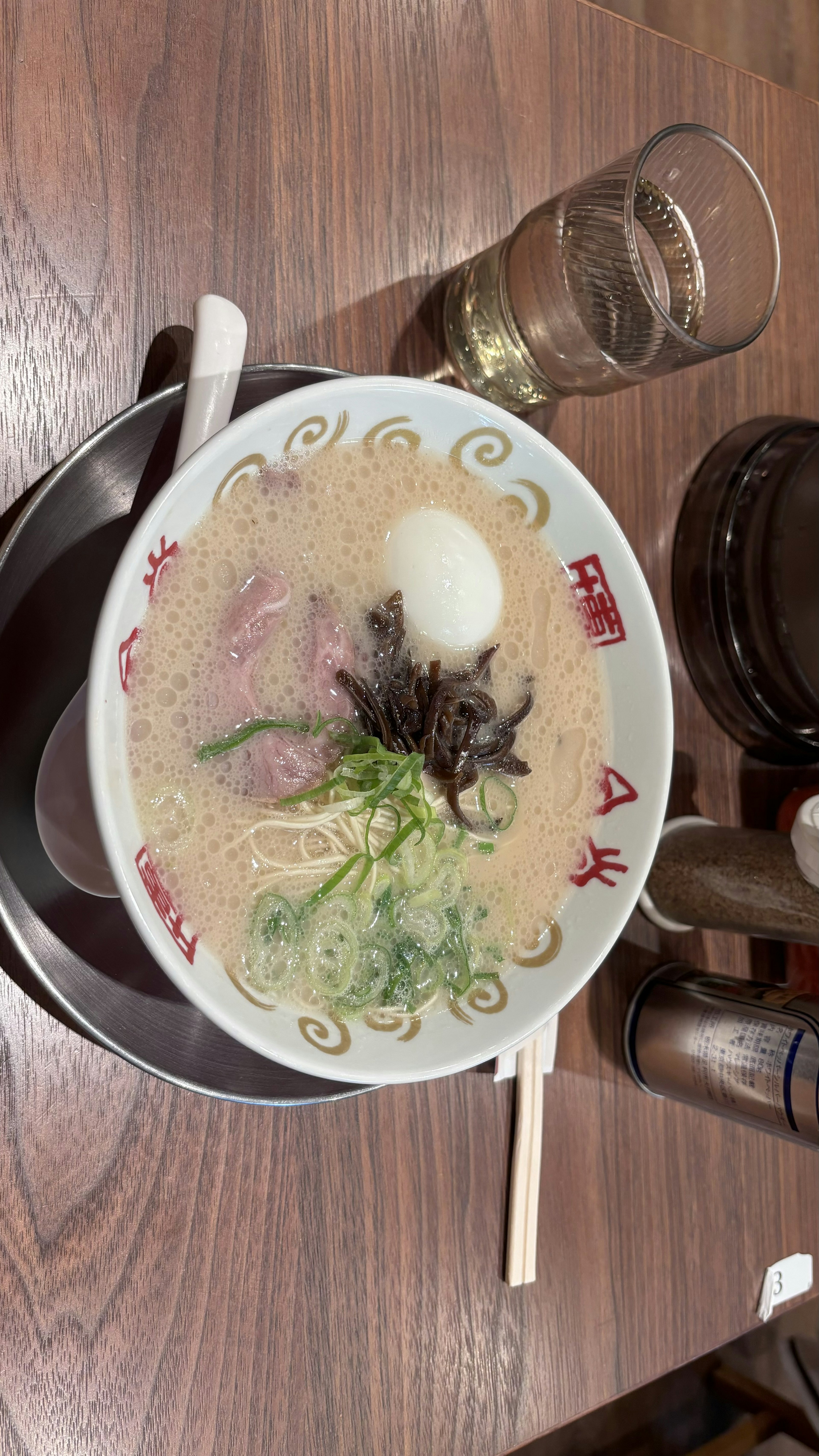 A bowl of ramen with egg seaweed and green onions