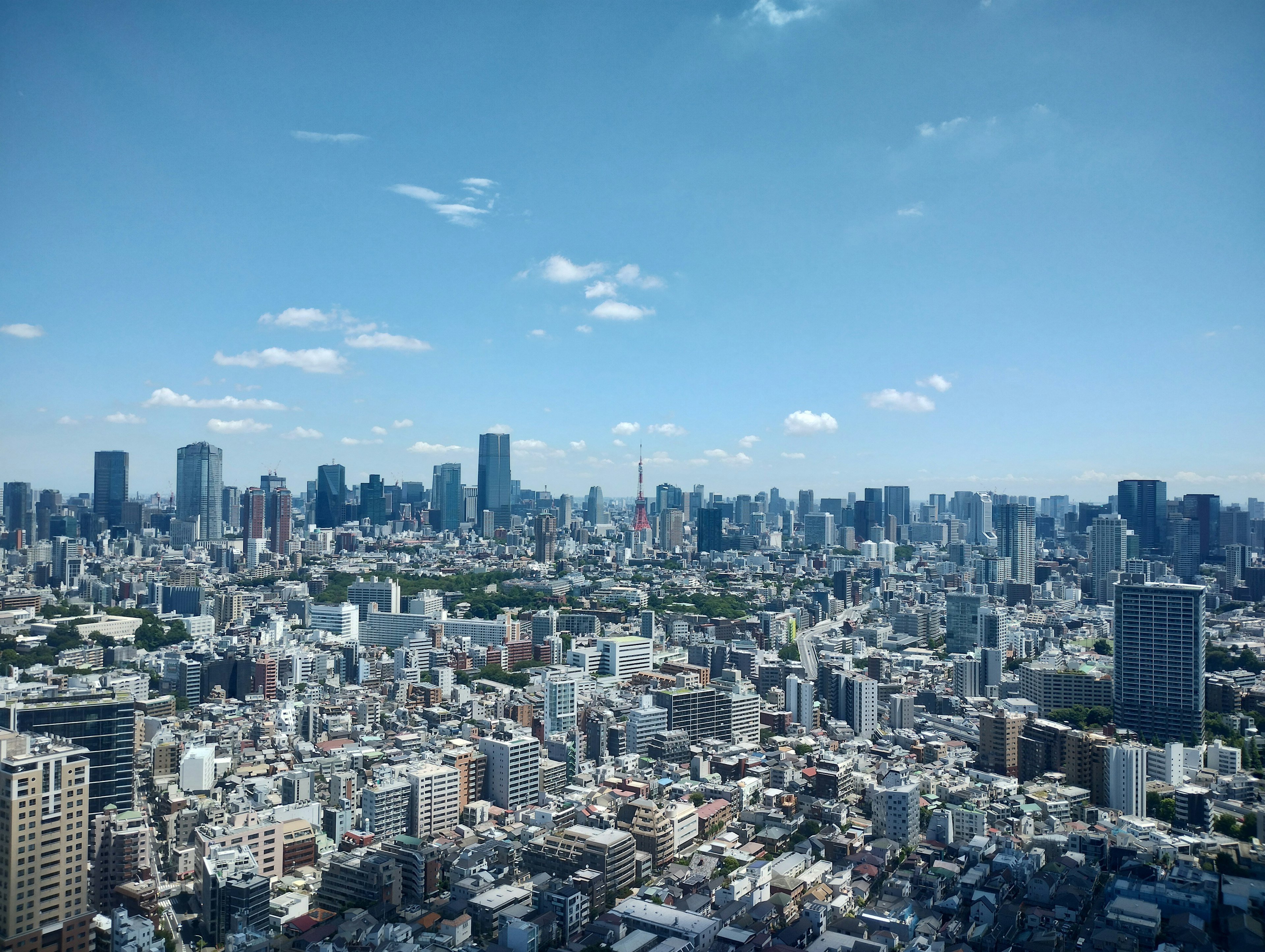 Una vista panoramica dello skyline di Tokyo con grattacieli e un cielo blu chiaro