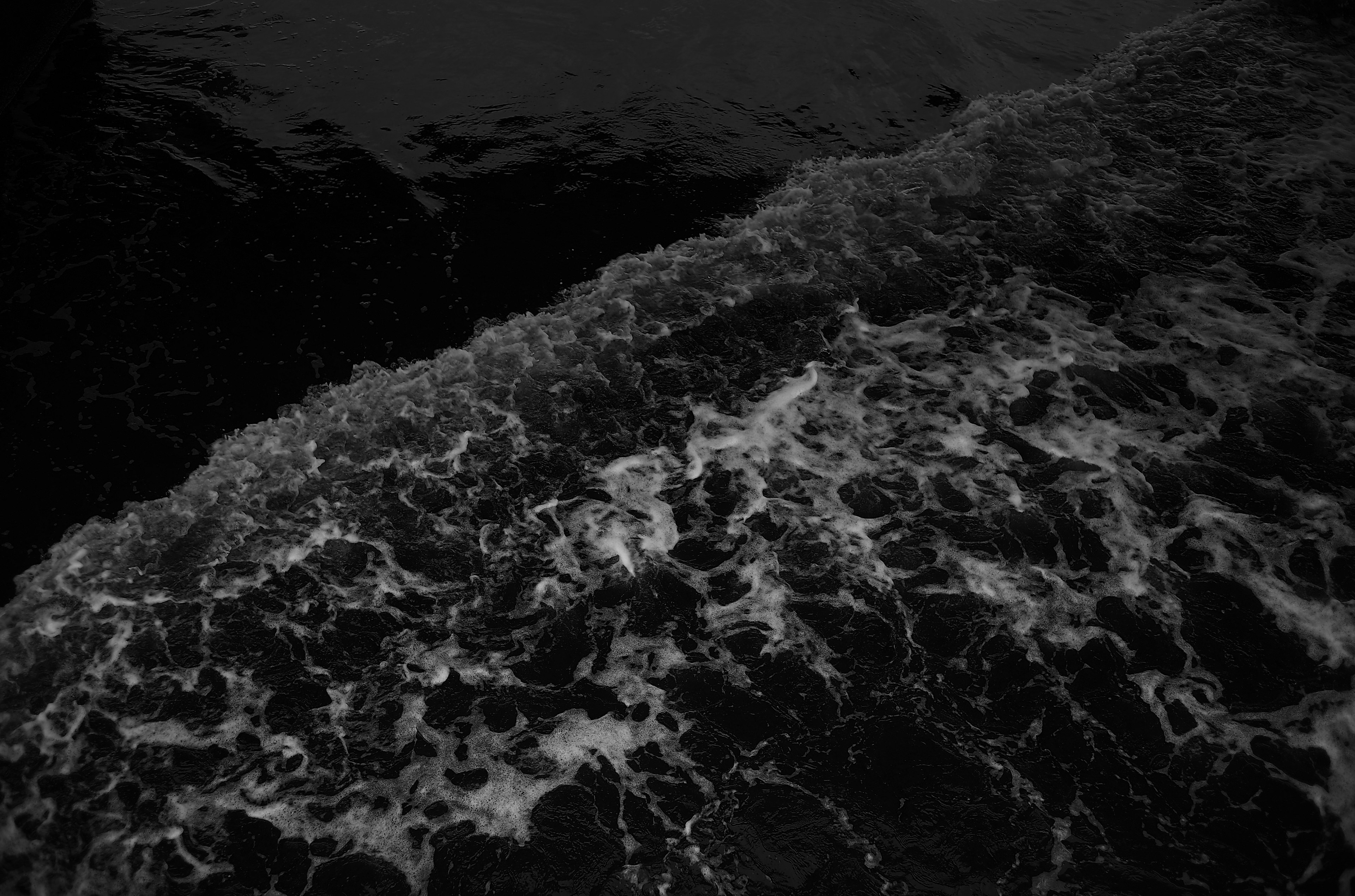 Dark ocean waves with white foamy crests