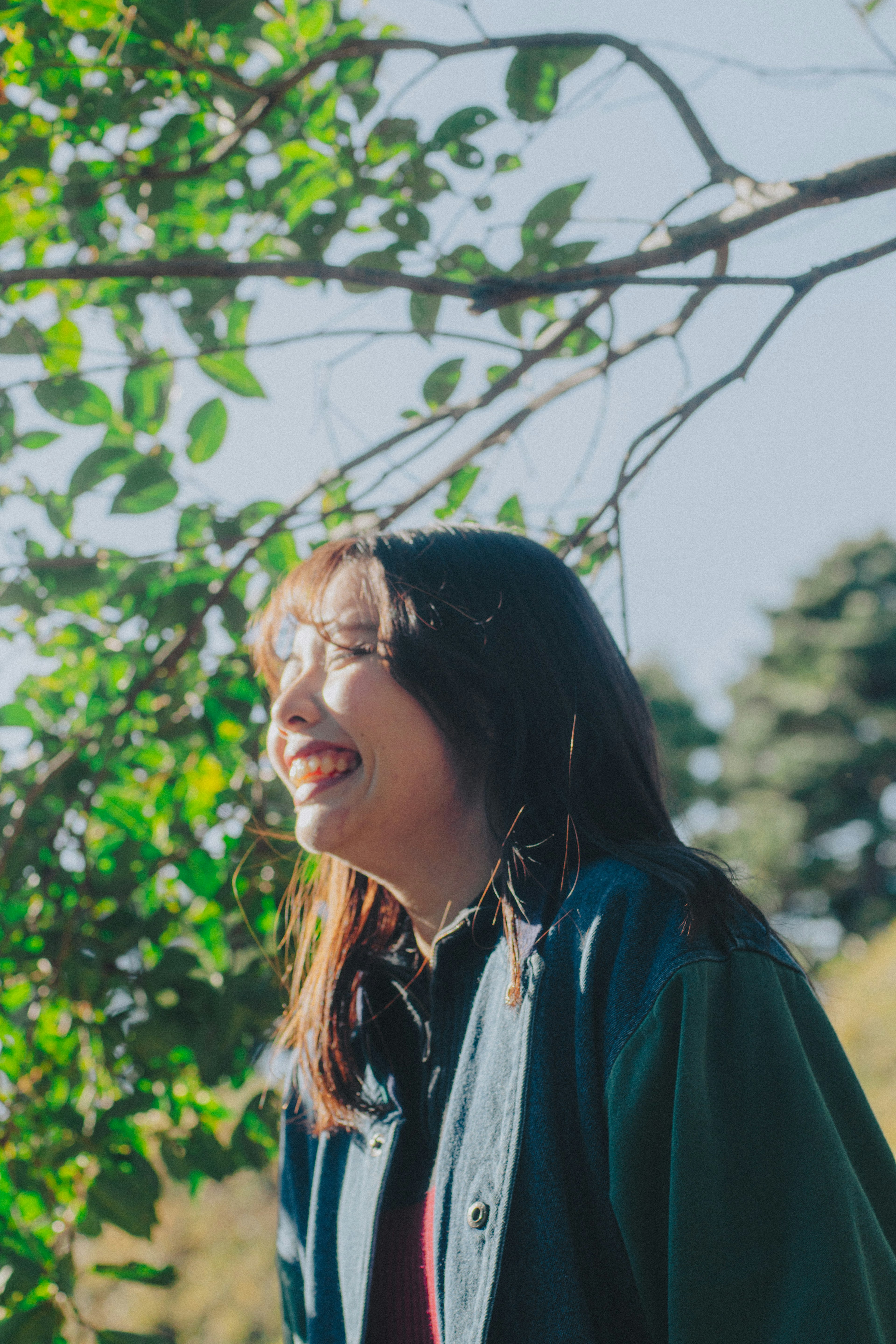 Smiling woman standing among green leaves