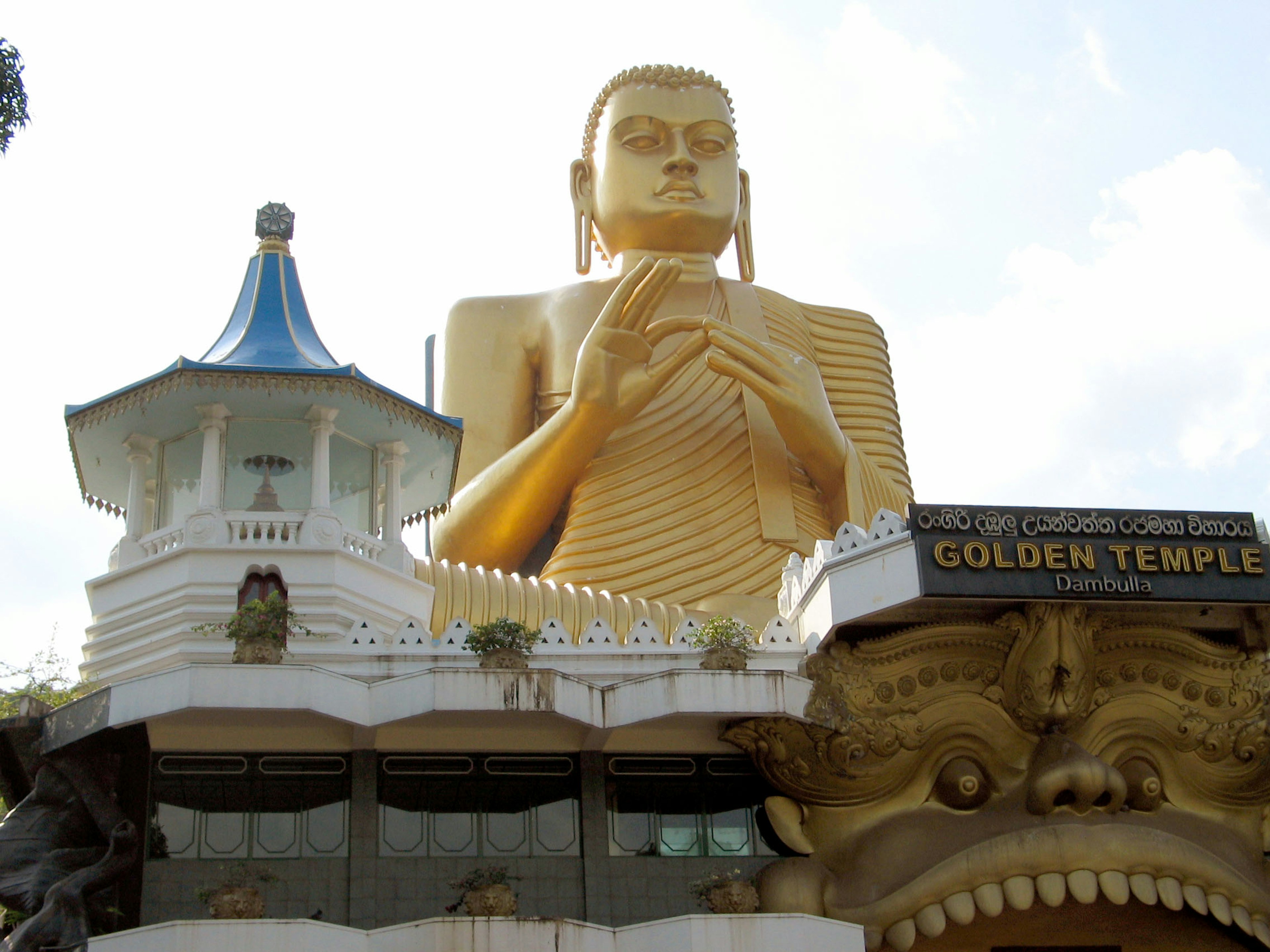 Estatua dorada de Buda con una estructura de templo de fondo