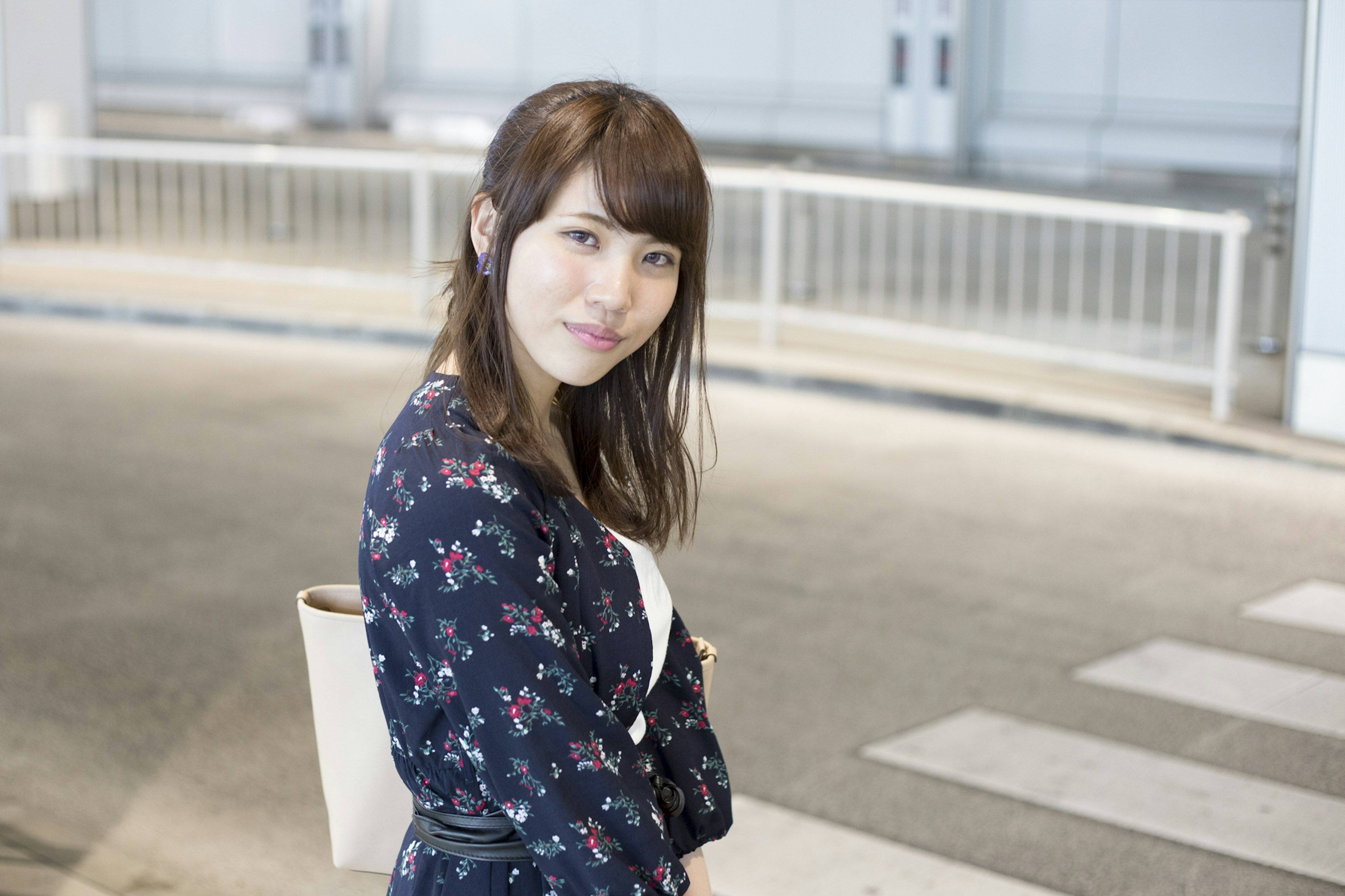 Portrait of a smiling woman in a bright setting wearing a floral dress