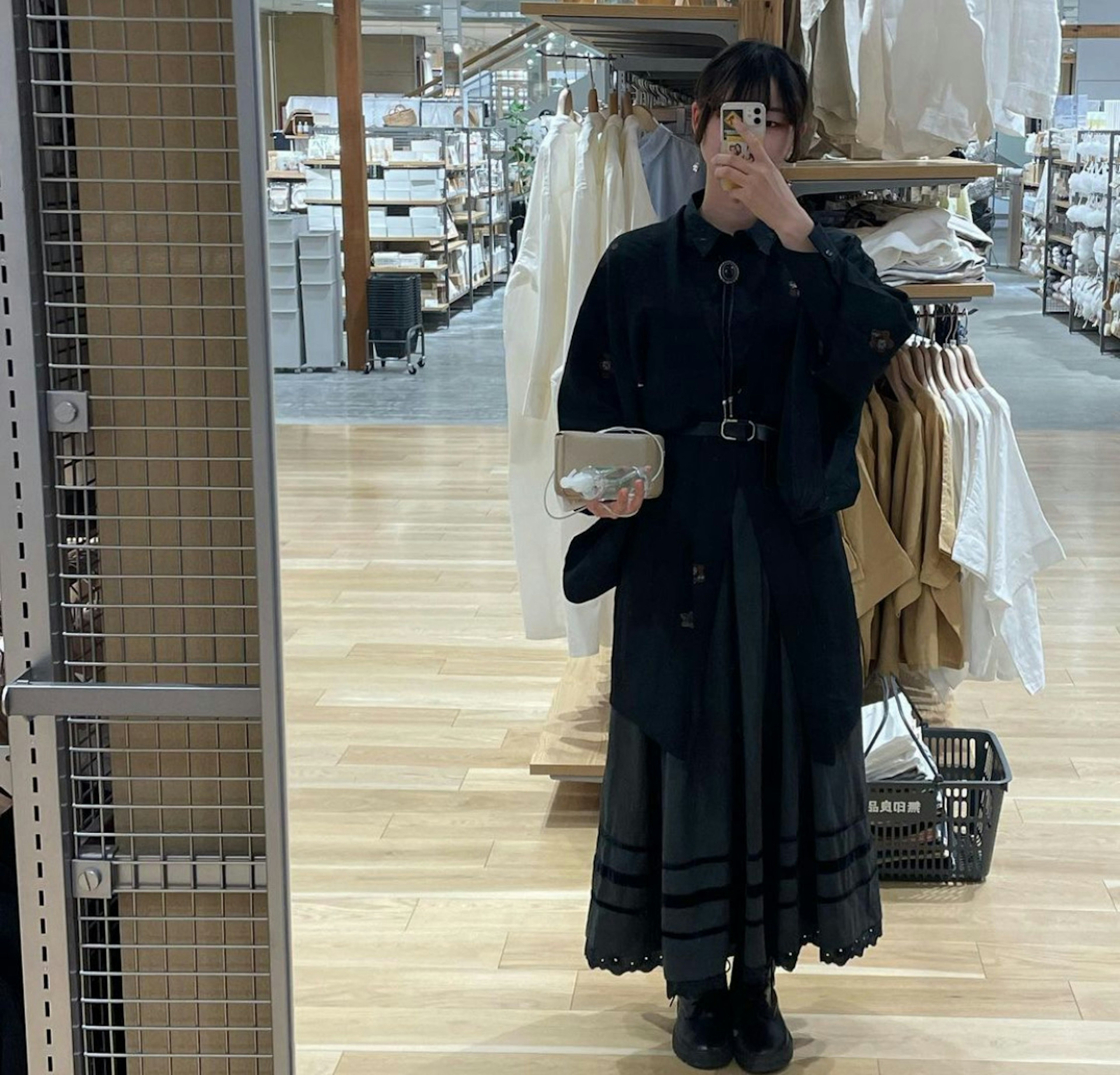 Une femme en manteau noir posant devant un miroir