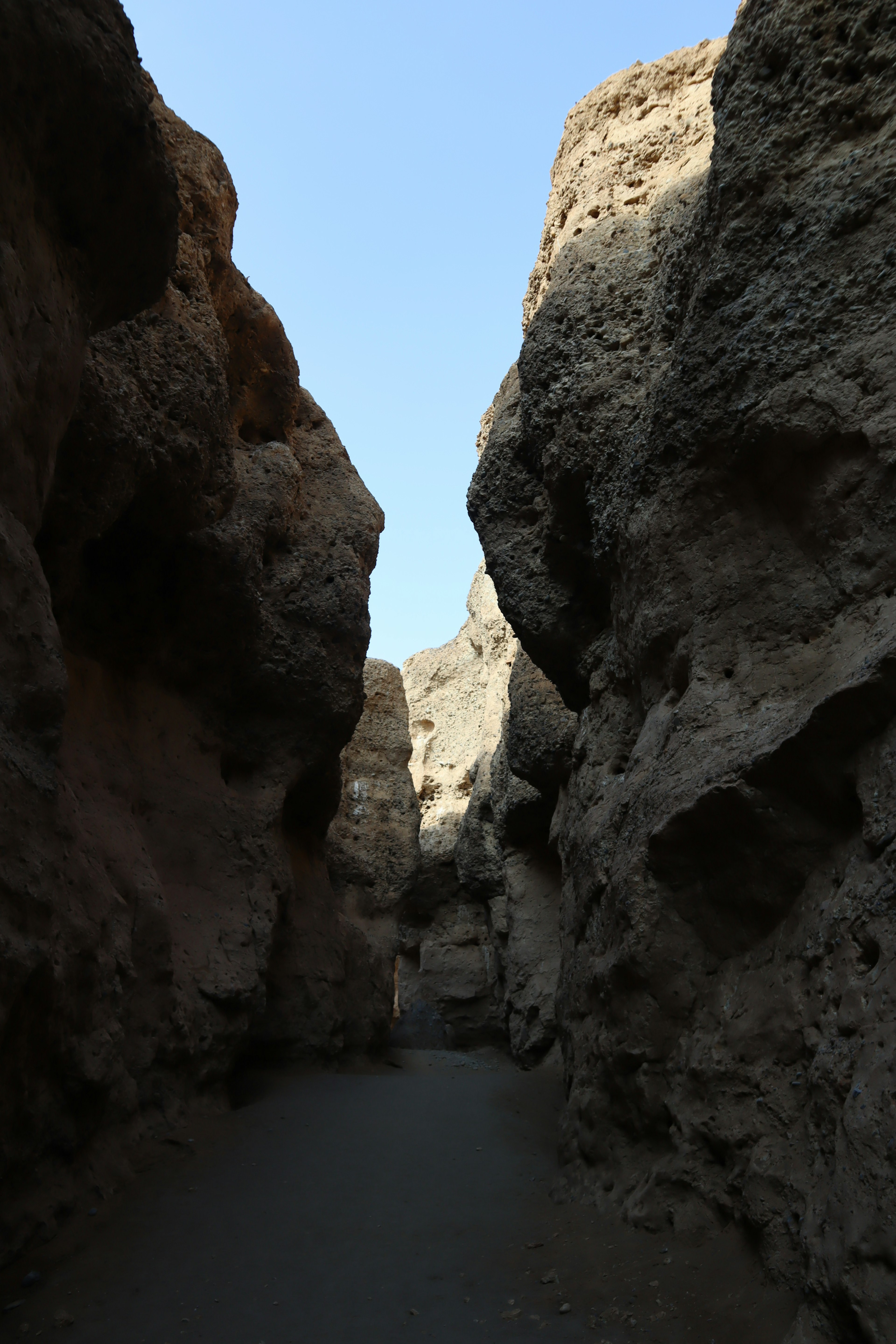 Narrow canyon landscape with towering rock formations on both sides