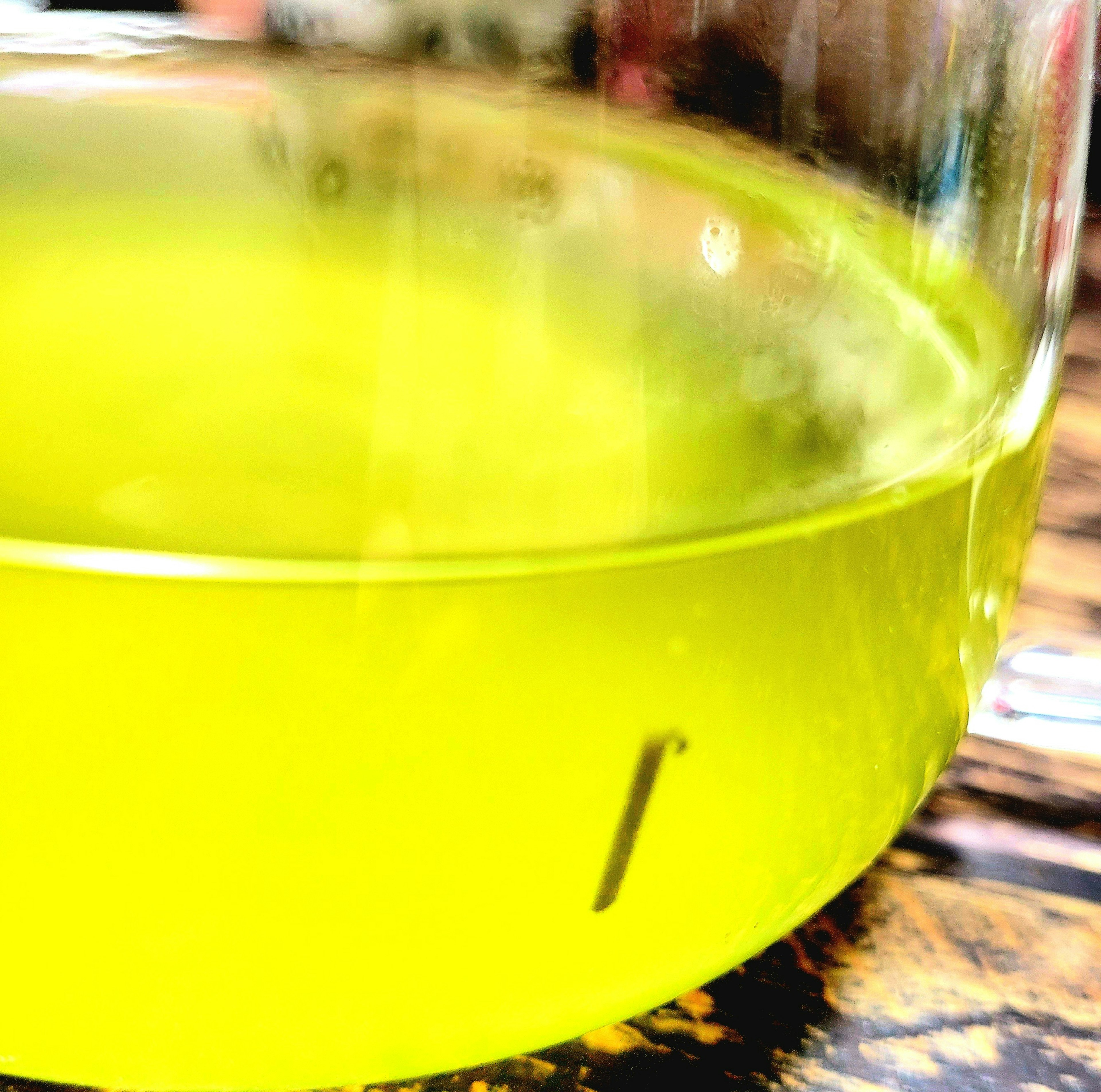 A transparent container filled with vibrant yellow liquid