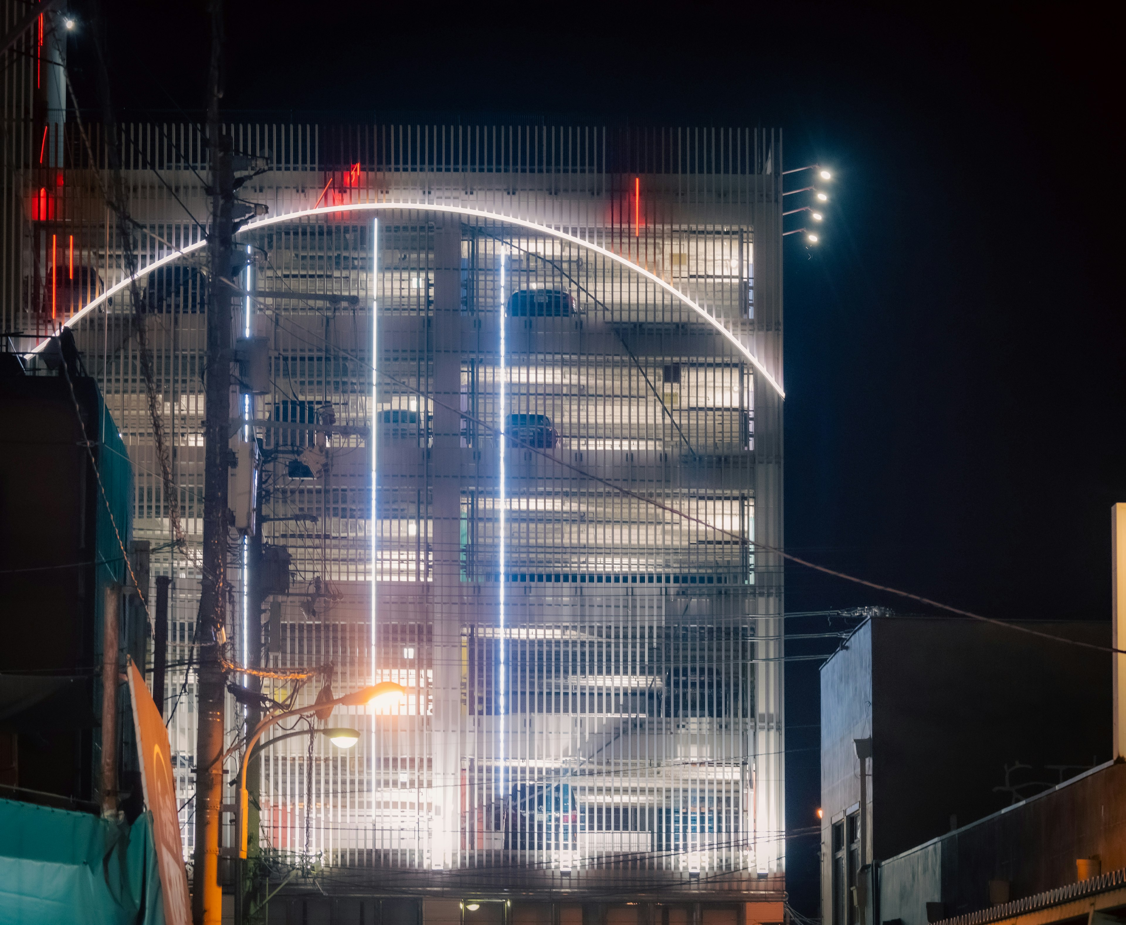 Garage de stationnement moderne illuminé la nuit avec un arc de lumières frappant