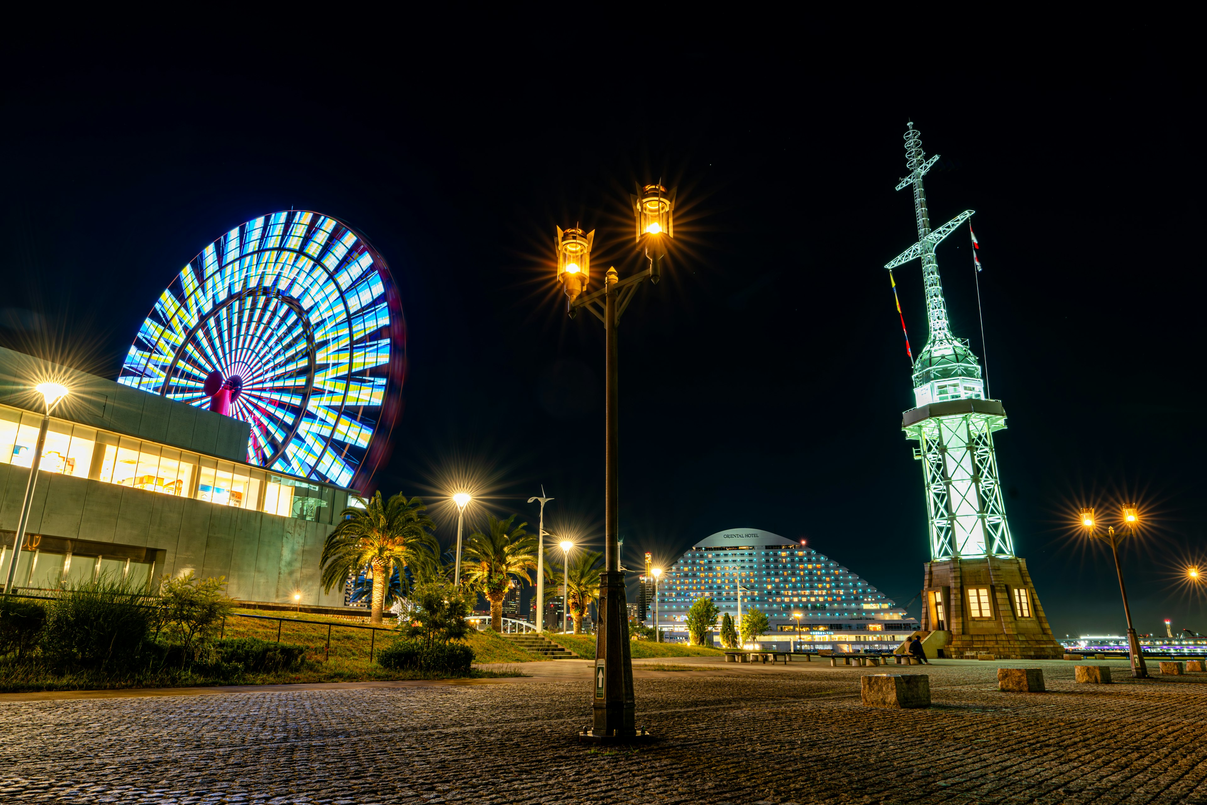 夜の観覧車と灯籠のある海辺の風景